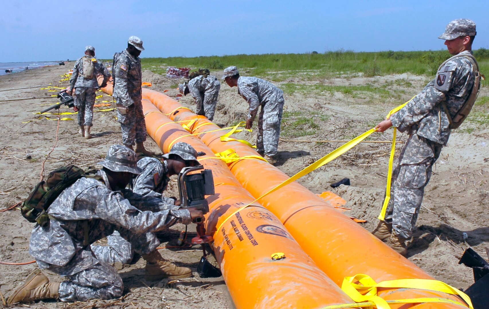 Soldiers with the Louisiana National Guard's 1023rd Vertical Engineer Company, 528th Engineer Battalion, anchor and strap down tubing for the shoreline protection system in the southwest pass of the Mississippi River delta near Venice, La., May 18, 2010, The 1023rd is constructing a more mthan seven-mile long barrier to prevent any possible oil from coming in to the wetlands.
