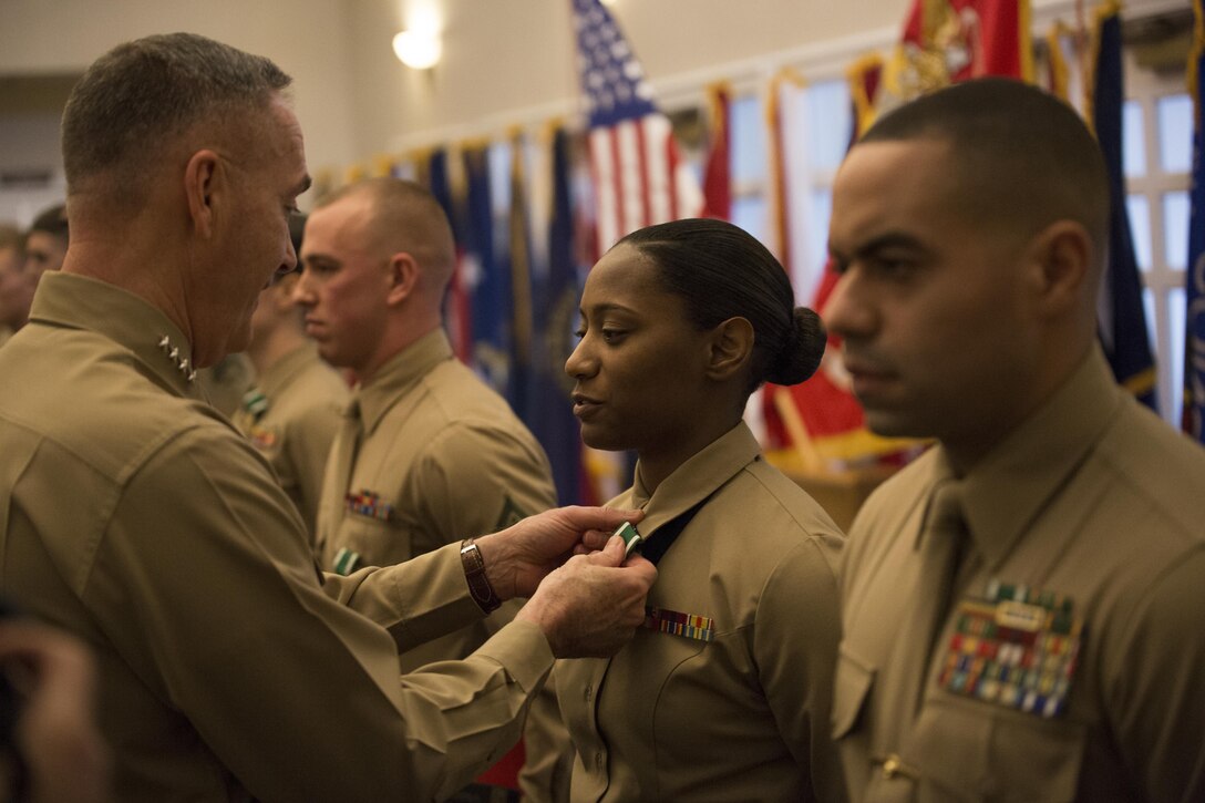 The Commandant of the Marine Corps Gen. Joseph F. Dunford Jr. pins the Navy and Marine Corps Commendation medal onto Staff Sgt. Wyanika M. Christophe, the Reserve Career Planner of the year, from 4th Assault Amphibian Battalion, 4th Marine Division, Marine Forces Reserve, during the Commandant of the Marine Corps 2014 Combined Awards Ceremony in Quantico, Va., Jan. 29, 2015. The ceremony recognized superior recruiters, drill instructors, combat Instructors, Marine security guards, career planners and Semper Fit male and female athletes of the year. Career planners play a critical role in retaining high quality Marines, an issue that the Commandant highlighted in his recently released planning guidance. (U.S. Marine Corps photo by Cpl. Gabrielle Quire/Released)