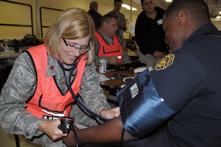 Maj. Julie Carpenter, Medical (Chemical, Biological, Radiological, Nuclear, or Explosive) Enhanced Response Force, conducts a preliminary health assessment on a firefighter from the Jersey City Hazmat Team, Jersey City Fire Department, N.J., before he conducts field operations and recovery during the Regional Mass Fatality Management Training Evolution at the U.S. Army Reserve Center/Jersey City Police Facility in Jersey City, N.J.,  May 11, 2010.