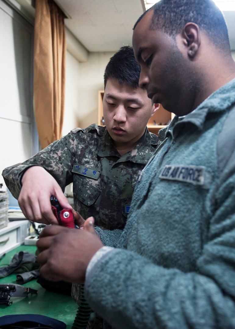 DAEGU AIR BASE, Republic of Korea  (Feb. 4, 2015) - Senior Airman Sang Won Lee, 120th Fighter Squadron aircrew flight equipment technician (left), and Senior Airman John Temple, 8th Operations Support Squadron aircrew flight equipment journeyman, prepare to conduct a 12-p mask fit test during Exercise Buddy Wing 15-2. Conducted multiple times a year to promote cultural awareness and sharpen combined combat capabilities, Wolf Pack Airmen worked alongside their ROKAF counterparts during the four-day exercise. ) 
