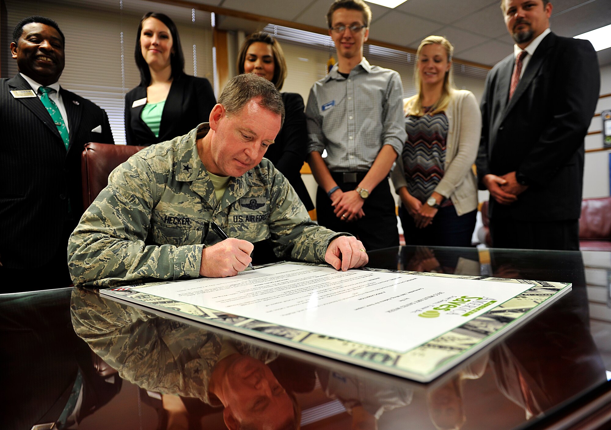 U.S. Air Force Brig. Gen. James Hecker, 18th Wing commander, signs the Military Saves Week proclamation board on Kadena Air Base, Japan, Feb. 4, 2015. Military Saves Week is scheduled to run from Feb. 23-28, and this year theme is "Build Your Saving Arsenal." The campaign is designed to persuade, motivate and encourage military families to save money every month, and to convince leaders and organizations to be aggressive in promoting automatic savings. (U.S. Air Force photo by Naoto Anazawa)