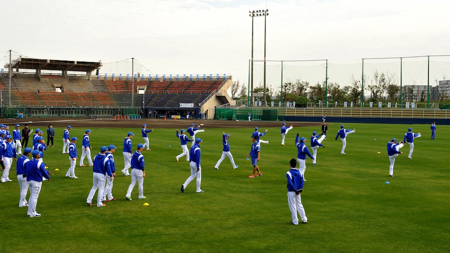 Yokohama DeNA Baystars warm-up during spring training camp at the Ginowan Municipal Baseball Stadium, Okinawa, Japan, Feb. 2, 2015. The camp is held on Okinawa due to the island's mild climate, the many professional baseball teams in the area that are available for practice games, and the abundance of sports facilities. (U.S. Air Force photo by Naoto Anazawa)