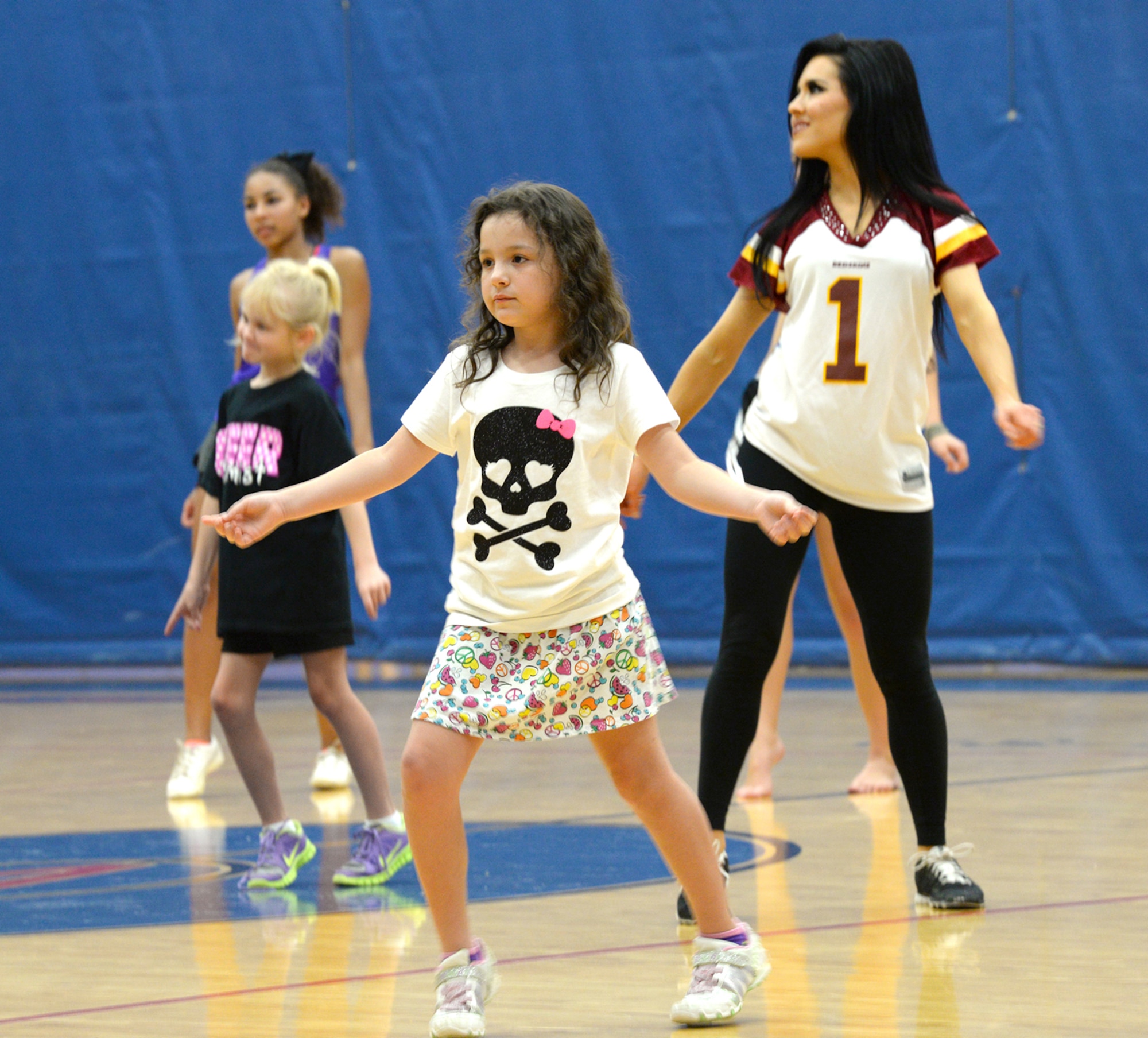 Team Andersen family members practice dance moves during a cheer clinic hosted by National Football League cheerleaders Feb. 1, 2015, at the Coral Reef Fitness Center at Andersen Air Force Base, Guam. The cheerleaders visited Andersen as part of the Department of Defense’s Armed Forces Entertainment Guam Super Bowl tour that brought the cheerleaders, NFL mascots and two former NFL players to the island for two days to meet military members and watch the Super Bowl Feb. 3 at Andersen and Naval Base Guam. (U.S. Air Force photo by Tech. Sgt. Zachary Wilson/Released)