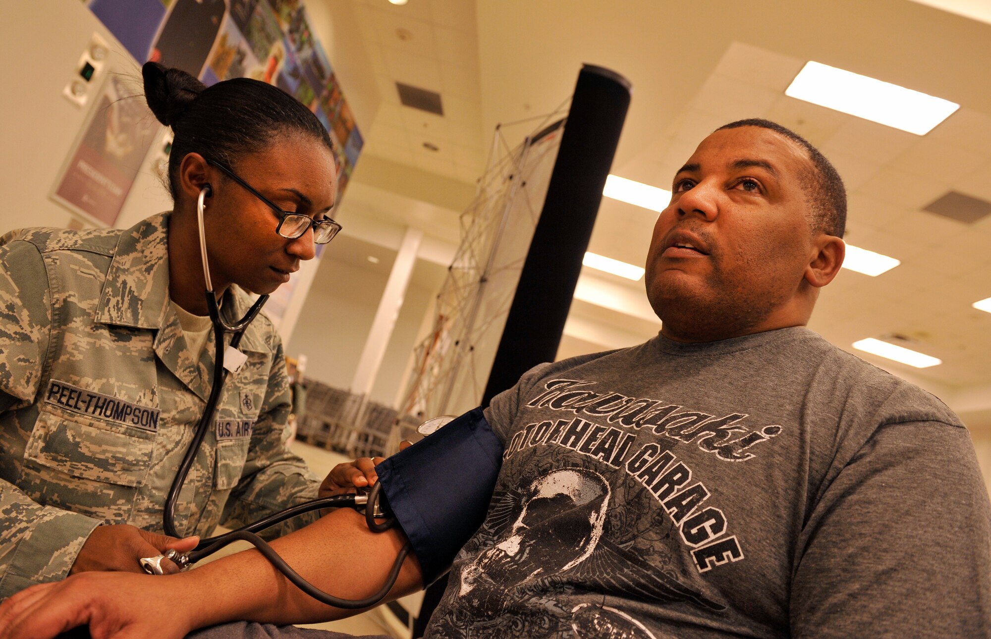 U.S. Air Force Staff Sgt. Alecia Peel-Thompson, 18th Medical Operations Squadron aerospace medical technician, checks the blood pressure of Kurt Smith, retired U.S. Army, during a Health Fair at the Exchange on Kadena Air Base, Japan, Feb. 3, 2015. People got a chance to talk and ask medical representatives questions about information and services available to them. (U.S. Air Force photo by Naoto Anazawa)