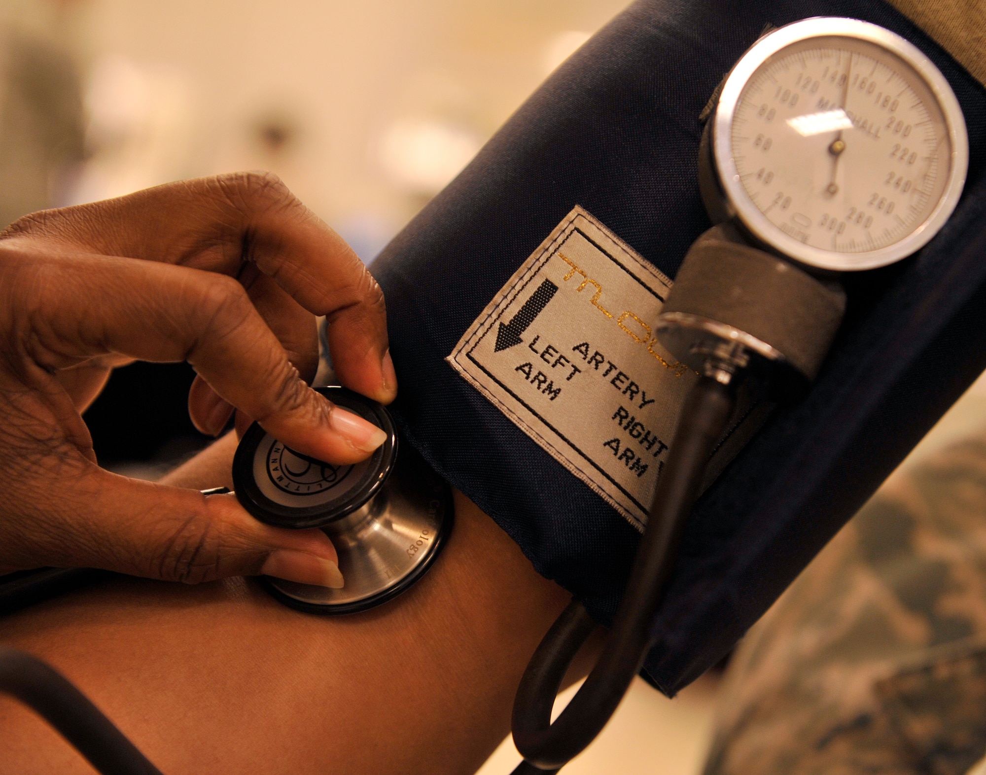 U.S. Air Force Staff Sgt. Alecia Peel-Thompson, 18th Medical Operations Squadron aerospace medical technician, checks the blood pressure of patient during a health fair at the Exchange on Kadena Air Base, Japan, Feb. 3, 2015. The blood pressure booths provided information for anyone with blood pressure issues. (U.S. Air Force photo by Naoto Anazawa)