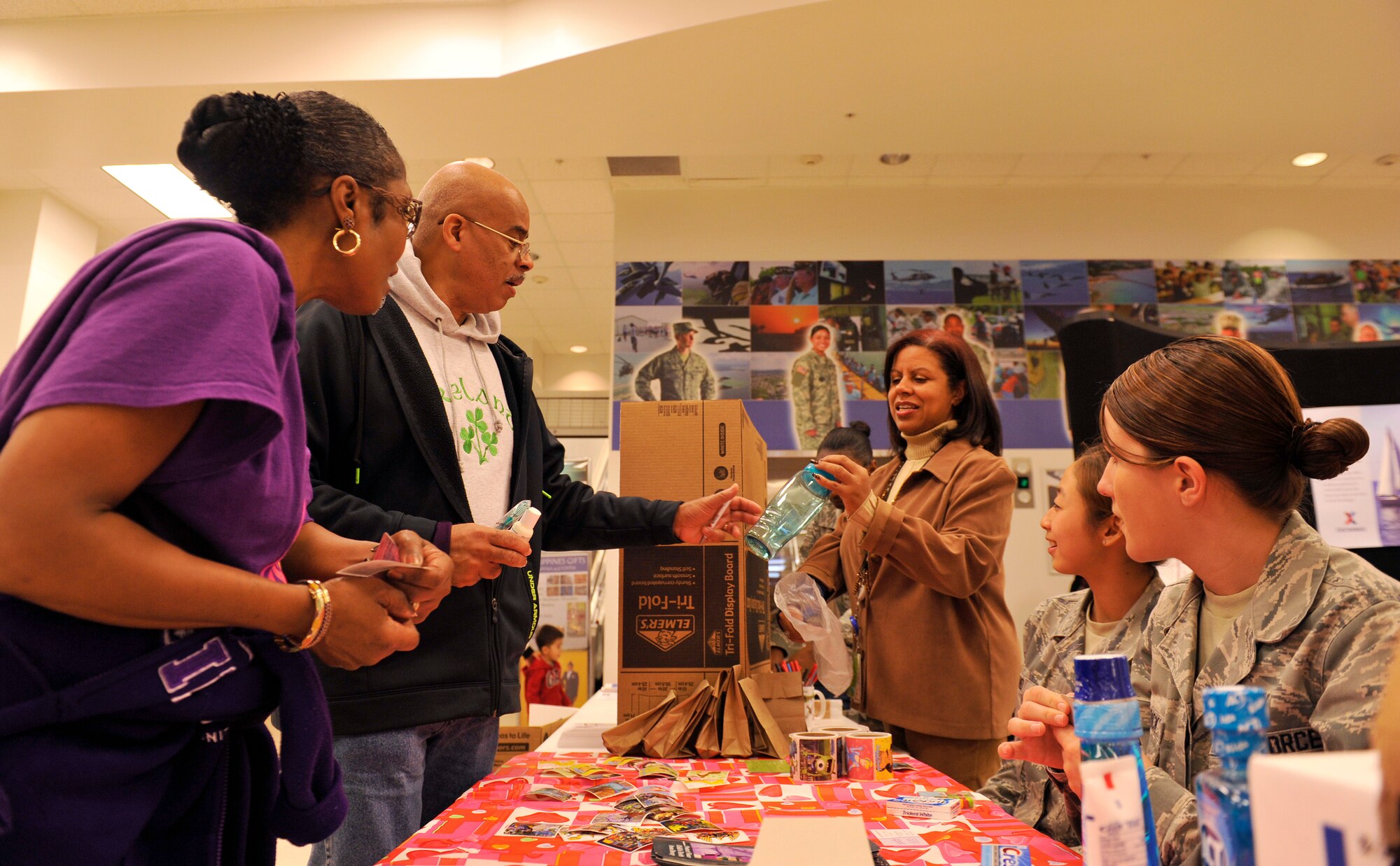 Alicia Denis, patient safety, gives away a free water bottle during a health fair at the Exchange on Kadena Air Base, Japan, Feb. 3, 2015. The health fair gave people the opportunity to speak with various health care representatives and ask them questions concerning their own health plans. (U.S. Air Force photo by Naoto Anazawa)