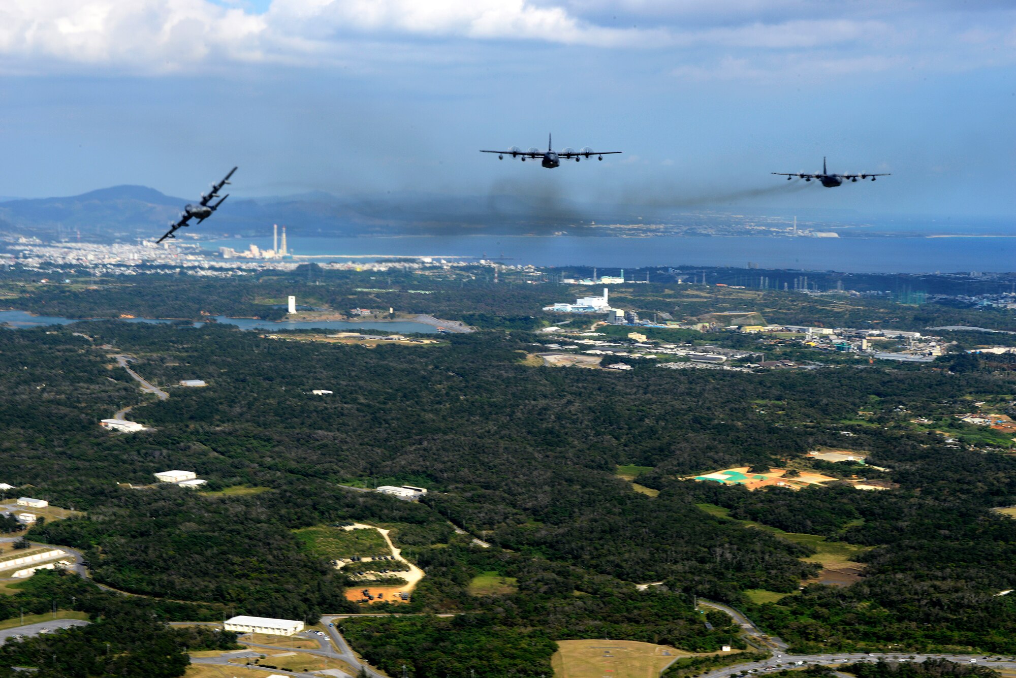 The MC-130P Combat Shadow breaks away from the heritage formation of three MC-130 variants over Okinawa, Japan, Jan. 26, 2015 symbolizing the retirement of the MC-130P and the continuing mission of the MC-130J Commando II and the MC-130H Combat Talon II. The 353rd Special Operations Group performed the unique formation to commemorate the enduringl egacy of MC-130 operations in the Pacific. (U.S. Air Force photo by Senior Airman Maeson Elleman)
