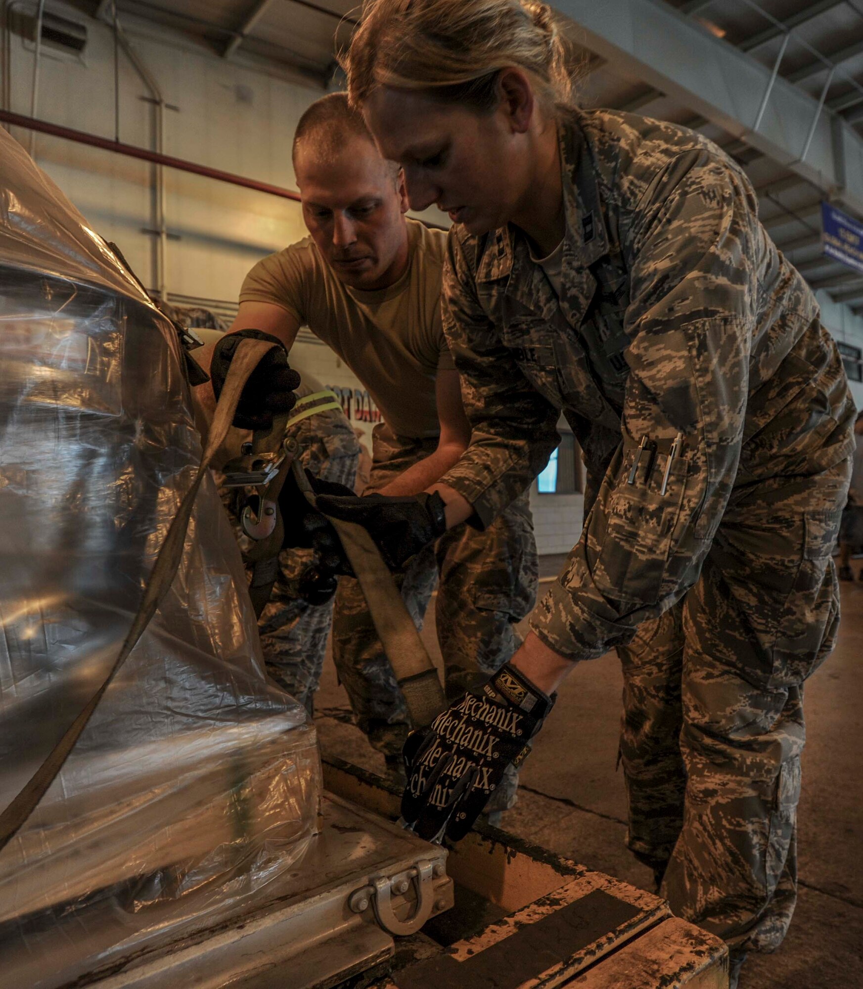 Tech. Sgt. George Welliver, 72nd Aerial Port Squadron cargo journeyman, left, shows Capt. Kelly Womble, 15th Maintenance Squadron Maintenance Flight commander, the tighten procedures for belly bands during a demonstration of palette buildup at the 735th Air Mobility Squadron Aerial Port at Joint Base Pearl Harbor-Hickam, Hawaii, Jan. 29, 2015. (U.S. Air Force photo by Tech. Sgt. Terri Paden)