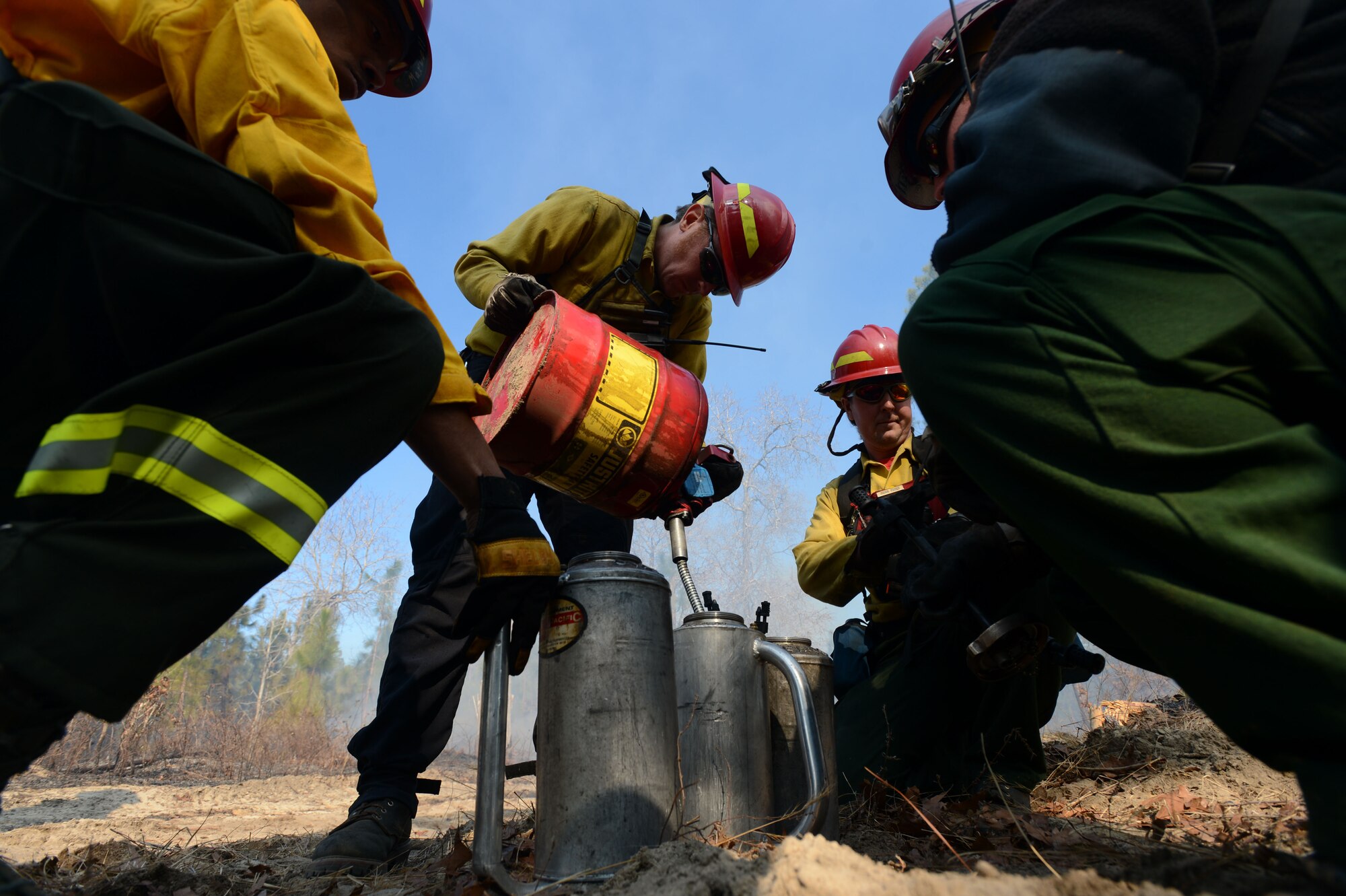 A U.S. Fish and Wildlife Service fire module detail member fills up a kerosene drip torch during a prescribed burn at the Poinsett Electronic Combat Range, Sumter, S.C., Jan. 28, 2015.  During the burn, several gallons of kerosene were used to enflame dry brush on the forest floor. (U.S. Air Force photo by Senior Airman Jensen Stidham/Released)