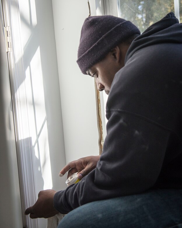 Staff Sgt. Ronald Mitchell, Air Force Mortuary Affairs Operations Fisher House manager, applies woodworker’s putty to a doorframe  while volunteering with Habitat for Humanity in Frederica, Del., Jan. 31, 2015. Mitchell said he was honored to help a family working through tough times. (U.S. Air Force photo/Capt. Raymond Geoffroy) 