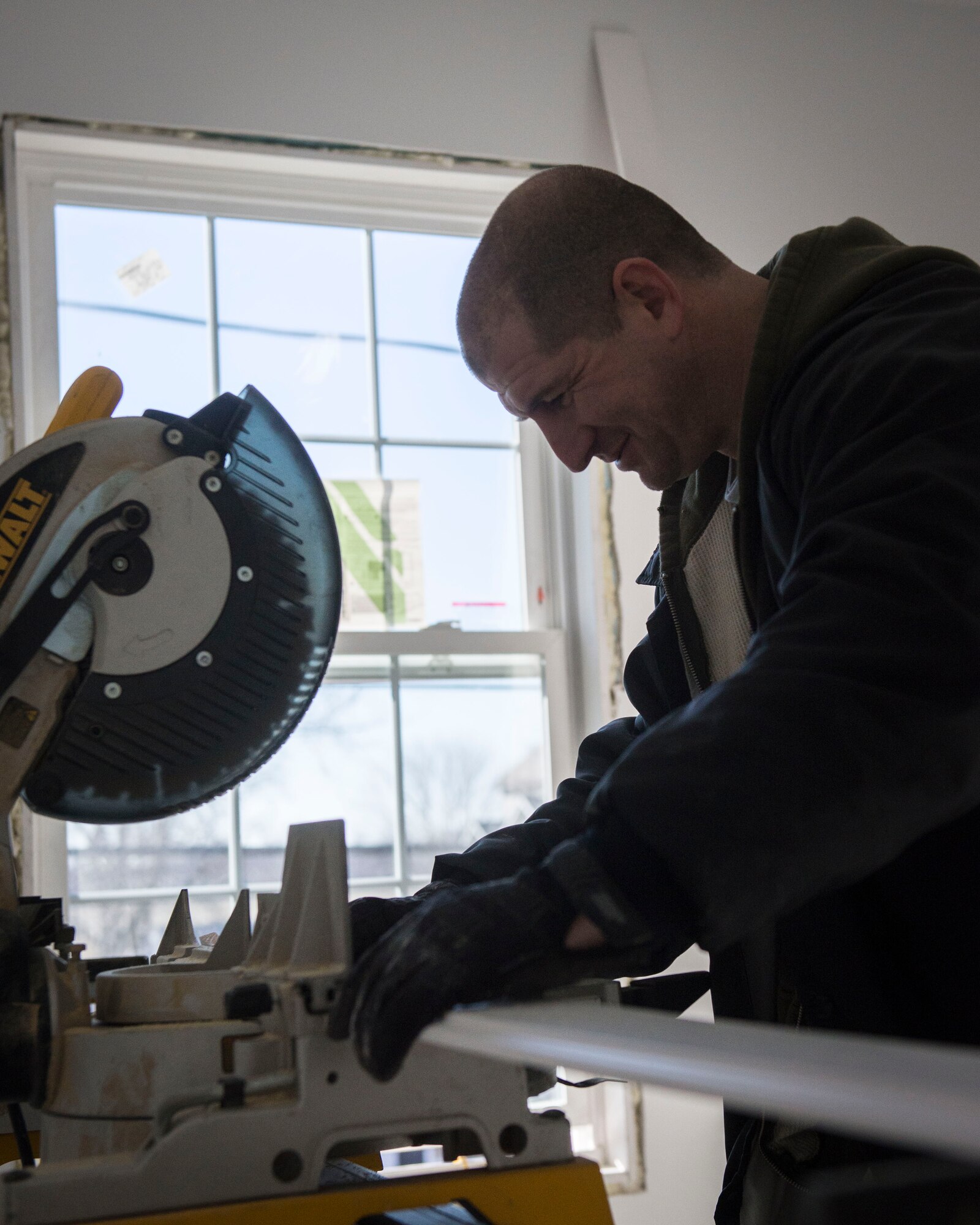 Senior Master Sgt. Brian Denny Air Force Mortuary Affairs Operations superintendent, prepares to cut a piece of trim while volunteering with Habitat for Humanity in Frederica, Del., Jan. 31, 2015. The all-AFMAO volunteer team spent the day installing door frames, applying trim, securing floor boards and performing other construction tasks. (U.S. Air Force photo/Capt. Raymond Geoffroy) 
