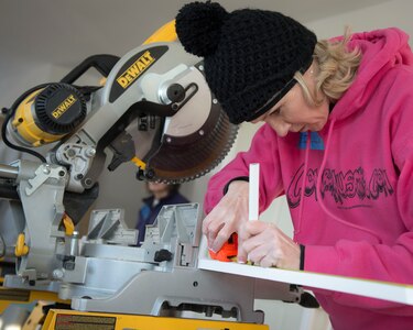 Master Sgt. Jillian Swanson, Air Force Mortuary Affairs Operations unit training manager, measures a piece of trim while volunteering with Habitat for Humanity in Frederica, Del., Jan. 31, 2015. More than a dozen AFMAO Airmen volunteered their Saturday to help build a home for a family in need. (U.S. Air Force photo/Capt. Raymond Geoffroy) 