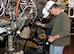 ATA Test Engineer Darren Carroll, pictured in front, assists as Pratt & Whitney Test Engineer Ronnie Thomas does a borescope inspection of the fan on the F135 engine. (Photo by Jacqueline Cowan)