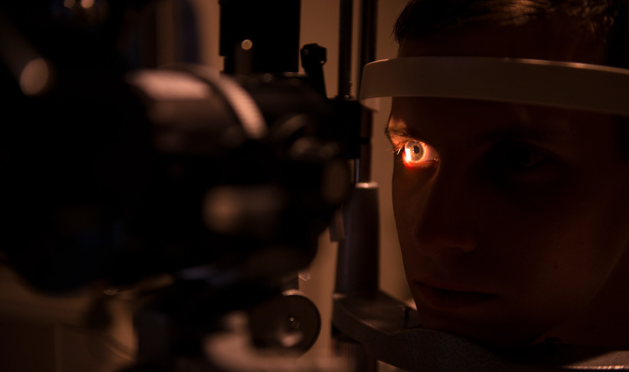A slit lamp examines the eye of U.S. Air Force Senior Airman River Carson, 23d Medical Group public health technician, during an optometry appointment Feb. 4, 2014, at Moody Air Force Base, Ga. The slit lamp magnifies the image of the eye to assist in detecting diseases such as diabetes and glaucoma. (U.S. Air Force photo by Airman 1st Class Ceaira Tinsley/Released)