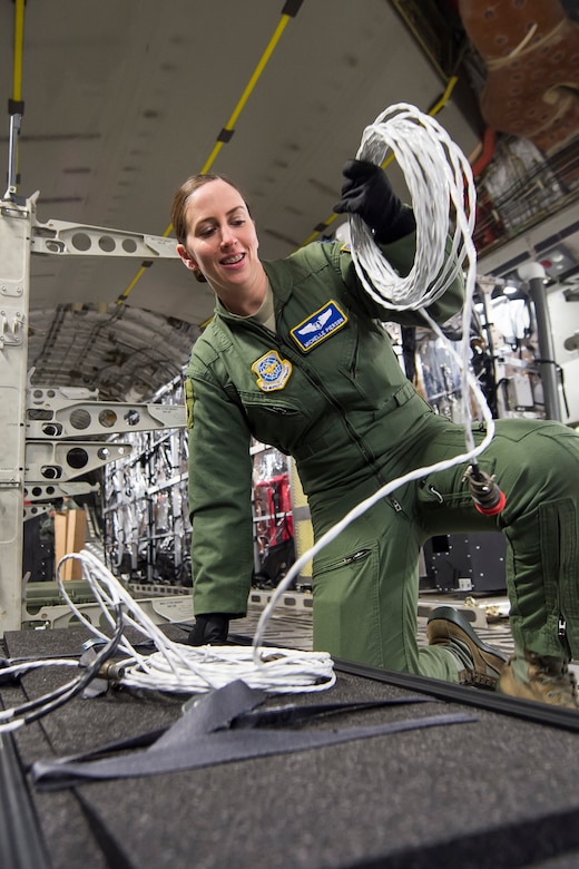 Capt. Michelle Pierson, unravels an extension cable which gives power to a Transport Isolation System aboard a C-17 Globemaster III, Jan. 14, 2015 at Joint Base Charleston, S.C., during a training exercise. Charleston is one of two bases in the United States that has trained with the TIS, a medical pod which provides a way to safely transport patients with infectious diseases. Pierson is a member of the 375th Aeromedical Evacuation Squadron at Scott Air Force Base, Ill. (U.S. Air Force photo/Senior Airman Jared Trimarchi)  
