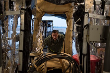 Staff Sgt. Austin Sissel pushes part of a Transport Isolation System aboard a C-17 Globemaster III, Jan. 14, 2015 at Joint Base Charleston, S.C., during a training exercise. Charleston is one of two bases in the United States that has trained with the TIS, a medical pod which provides a way to safely transport patients with infectious diseases. Sissel is a member of the 437th Aerial Port Squadron. (U.S. Air Force photo/Senior Airman Jared Trimarchi)  