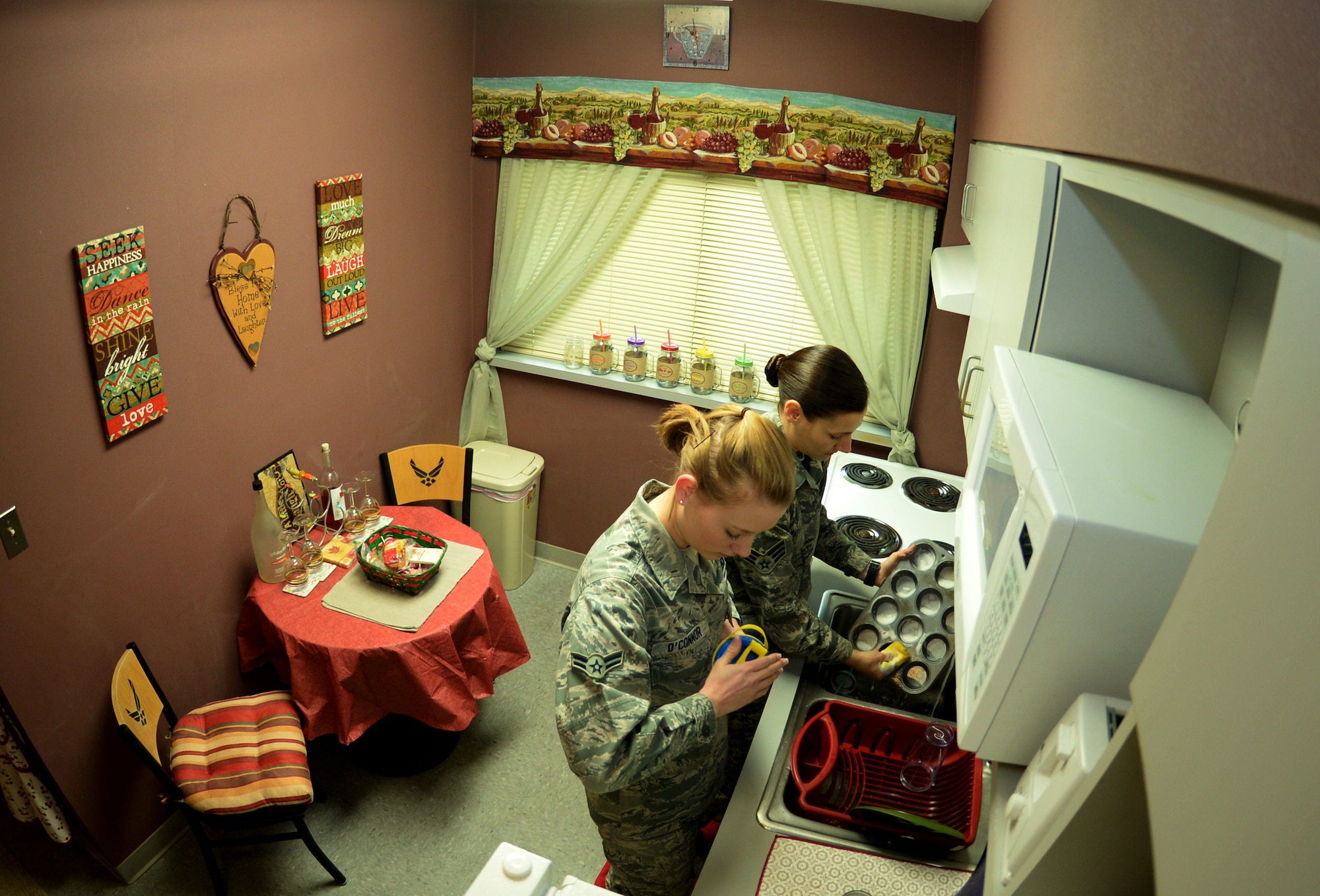 Airman 1st Class Lauren O?Connor, foreground, and Senior Airman Shellby Matullo, 2nd Bomb Wing Public Affairs broadcast journalists, wash dishes together in their shared kitchen on Barksdale Air Force Base, La., Feb. 2, 2015. One of the keys to success in sharing a living space is having open lines of communication which these Airmen maintain on a constant basis. (U.S. Air Force photo/Airman 1st Class Curt Beach)