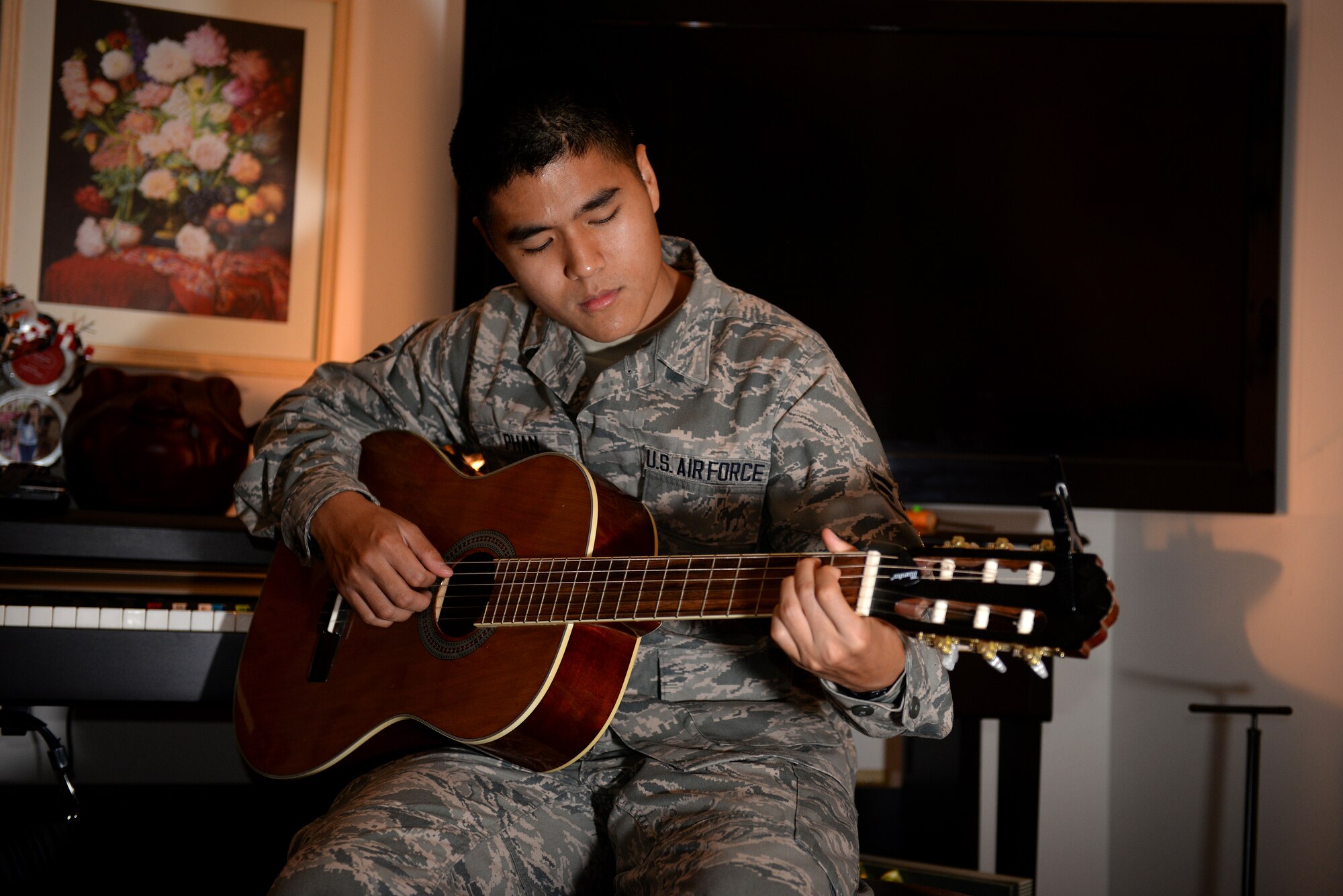 Airman 1st Class Linh Phan, 436th Supply Chain Operations Squadron, plays his guitar in his dorm room at Scott Air Force Base, Illinois. Phan uses music to as method to his resilience and stability. He began playing guitar in the eighth grade while living in Vietnam. (U.S. Air Force photo/Senior Airman Jake Eckhardt)