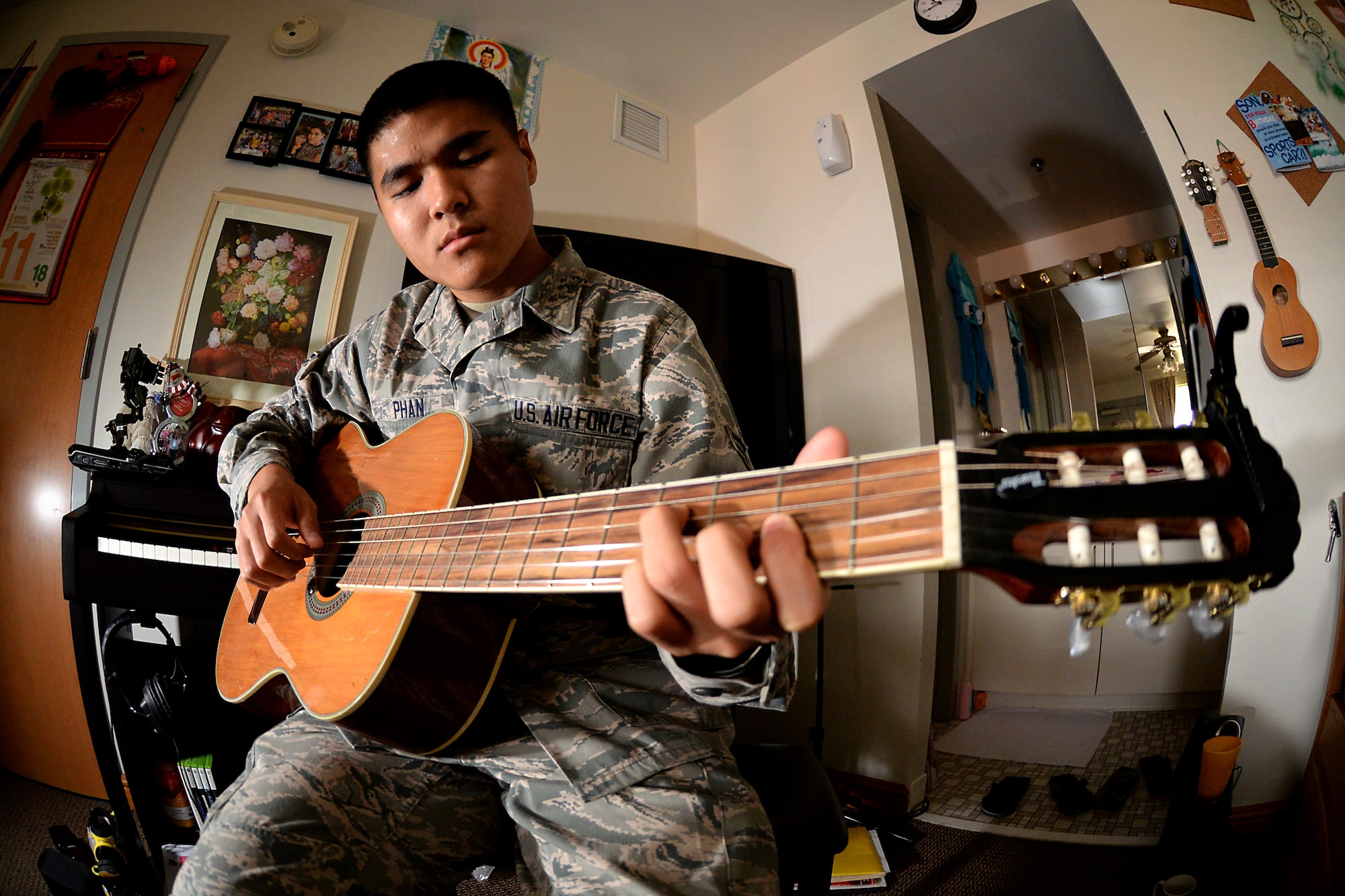 Airman 1st Class Linh Phan, 436th Supply Chain Operations Squadron, plays his guitar in his dorm room at Scott Air Force Base, Illinois. Phan uses music to as method to his resilience and stability. He began playing guitar in the eighth grade while living in Vietnam. (U.S. Air Force photo/Senior Airman Jake Eckhardt)