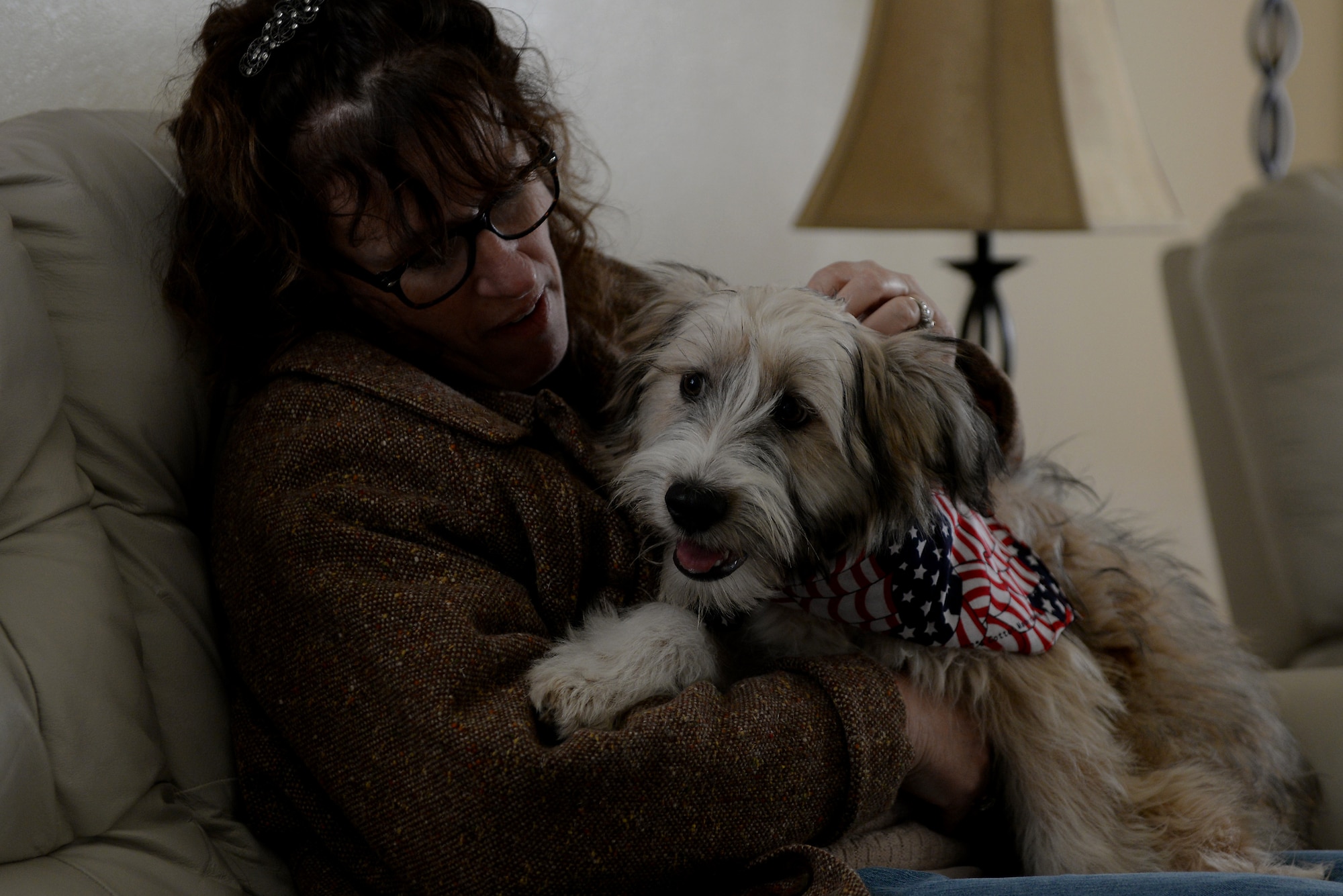 Sheila Ford, a retired Air Force aircraft maintainer, cuddles with Bandit, a terrier mix puppy, in his new home, Scott Air Force Base, Ill., Jan. 28, 2015. She ensured Bandit had a foster home to await his owner’s return. Staff Sgt. Arin Vickers, 435th Supply Chain Operations Squadron C-5 Stock Control Supervisor, rescued him on the streets of Kuwait and is slated to return to Scott later this year. (U.S. Air Force photo by Airman 1st Class Kiana Brothers)
