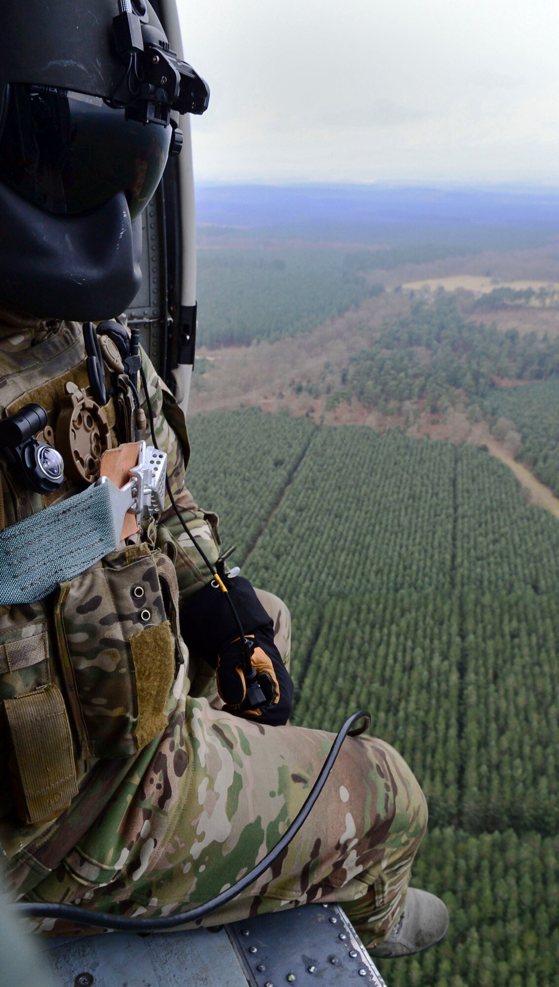 A 56th Rescue Squadron special missions aviator scans the area for hazards during an incentive flight over East Anglia, England, Jan. 30, 2015. Three HH-60G Pave Hawk rescue helicopter crews flew more than 130 members of wing leadership, the 56th RQS and their spouses to honor their contributions to base operations and expose them to the rescue mission. (U.S. Air Force photo by Staff Sgt. Thomas Trower/Released)