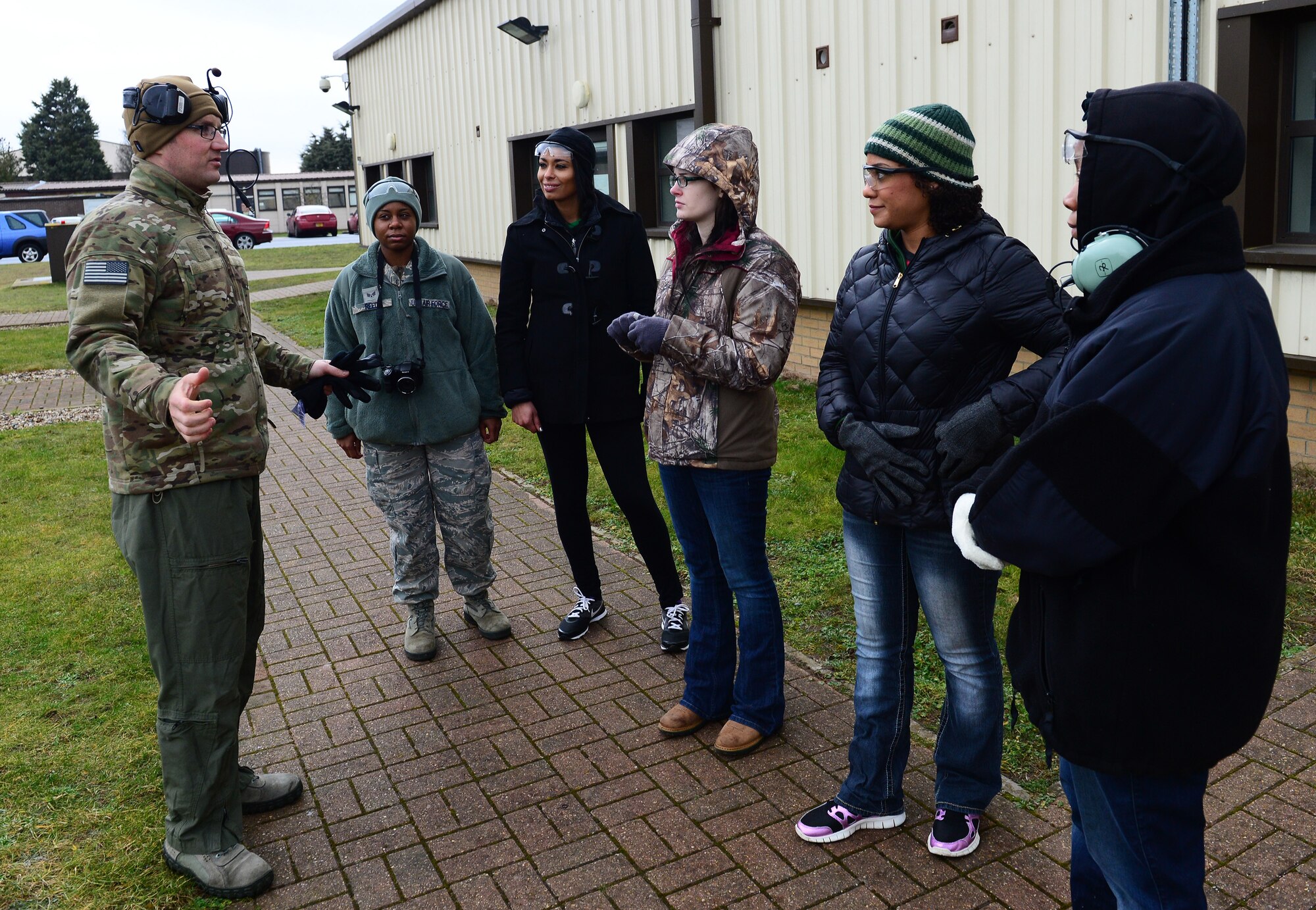Liberty Wing leadership and 56th Rescue Squadron spouses receive a safety briefing before boarding an HH-60G Pave Hawk rescue helicopter for an incentive flight at Royal Air Force Lakenheath, England, Jan. 30, 2015. Brief, 15-minute flights were conducted by three helicopter crews to honor contributions to base operations and expose them to the rescue mission. (U.S. Air Force photo by Staff Sgt. Thomas Trower/Released)