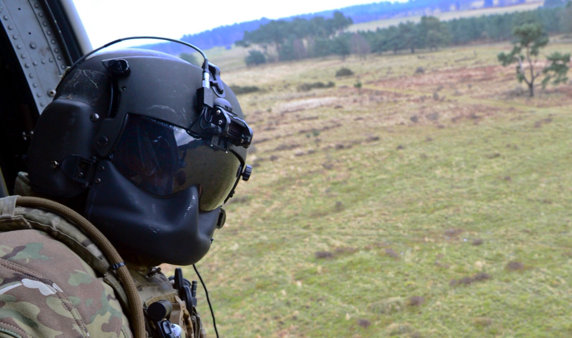 A 56th Rescue Squadron special missions aviator scans the area for hazards while hovering during an incentive flight over East Anglia, England, Jan. 30, 2015. Three HH-60G Pave Hawk rescue helicopter crews flew more than 130 members of wing leadership, the 56th RQS and spouses to honor their contributions to base operations and expose them to the rescue mission. (U.S. Air Force photo by Staff Sgt. Thomas Trower/Released)