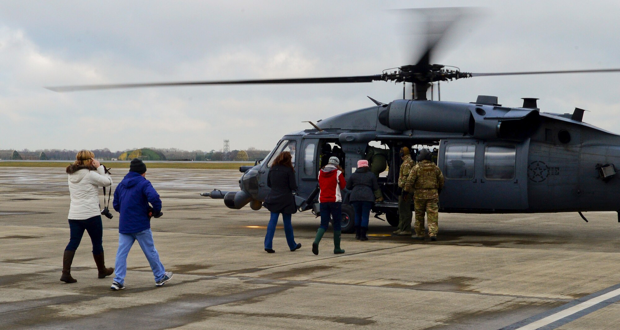 Spouses of Liberty Wing leadership and 56th Rescue Squadron members board an HH-60G Pave Hawk rescue helicopter for an incentive flight at Royal Air Force Lakenheath, England, Jan. 30, 2015. Brief, 15-minute flights were conducted by three helicopter crews to honor their spouse’s contributions to base operations and expose them to the rescue mission. (U.S. Air Force photo by Staff Sgt. Thomas Trower/Released)