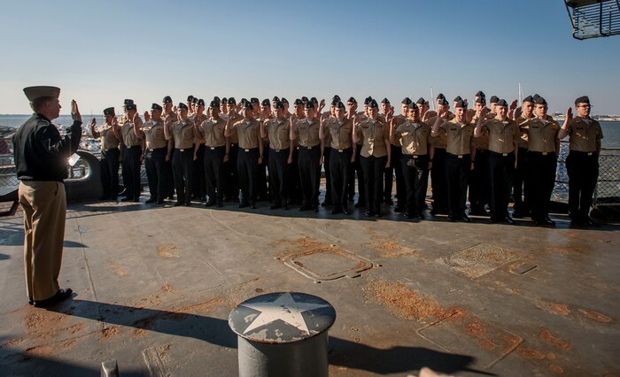 Navy Capt. Robert Hudson, Nuclear Power Training Unit commanding officer, conducts a re-enlistment ceremony with Sailors assigned to NPTU  Jan. 30, 2015, at Patriots Point Naval & Maritime Museum – Charleston, S.C. More than 40 Sailors re-enlisted into the U.S. Navy after a graduation ceremony. (U.S. Air Force Photo / Senior Airman Tom Brading)