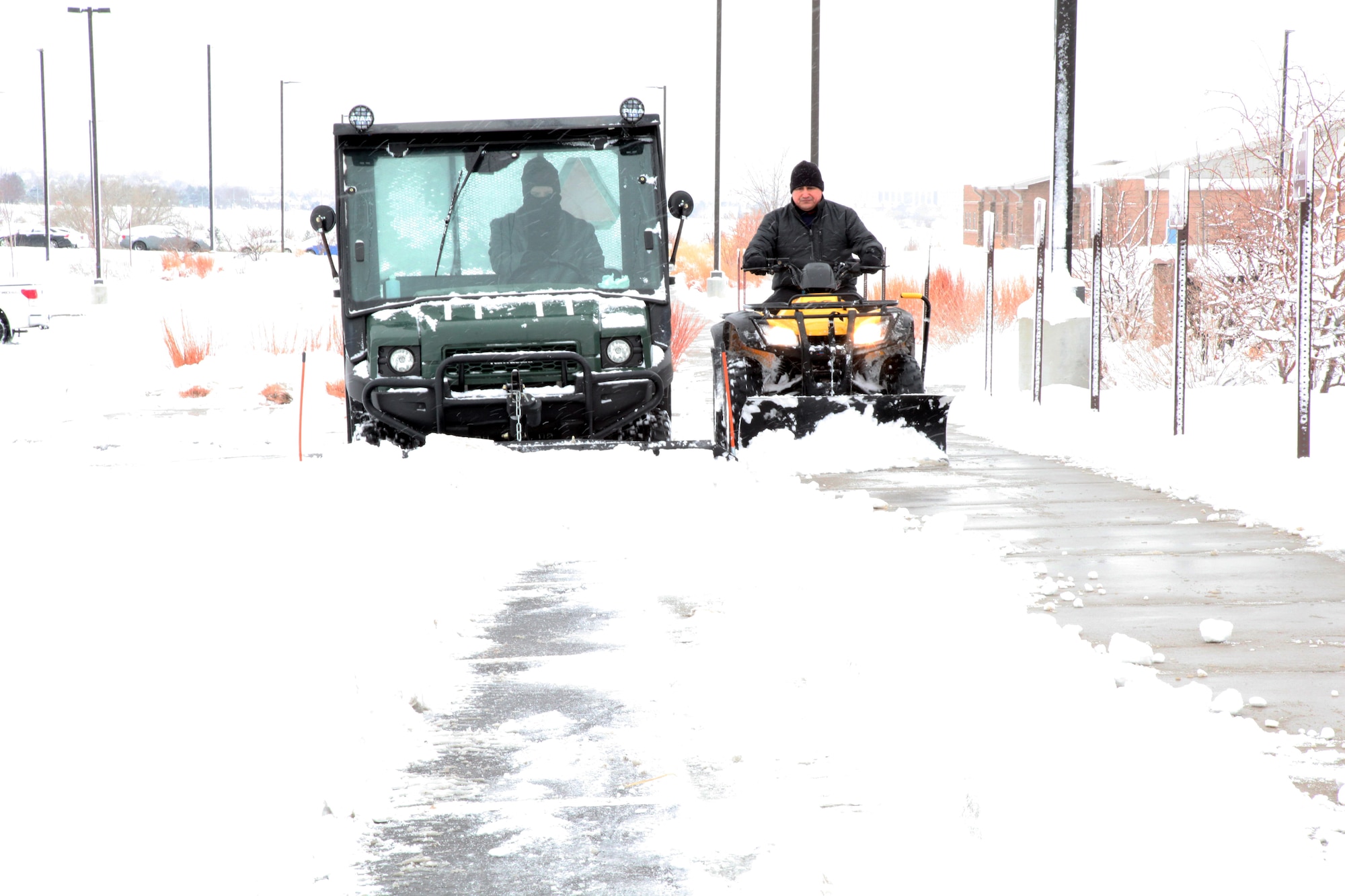Staff Sgt. Robert Short, Air Reserve Personnel Center evaluations technician, and Master Sgt. Javier Castro, ARPC system requirements analyst, work together to clear the sidewalks and loading dock at the ARPC headquarters building Feb. 1, 2015, on Buckley Air Force Base, Colo. While there are still seven weeks of winter remaining, it helps to know the ARPC snow removal team is available to clear a path during inclement weather for members and visitors at the ARPC headquarters building. (U.S. Air Force photo/Tech. Sgt. Rob Hazelett)