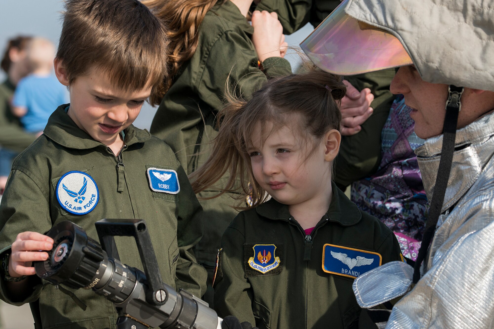 Robby and Katie Patchen check out the fire hose they'll use to spray down their dad, U.S. Air Force Lt. Col. Bryan Patchen, after he returns from his final mission in a B-52H Stratofortress, Jan. 28, 2015, Barksdale Air Force Base, La. Patchen is an 11th Bomb Squadron B-52 instructor pilot and is retiring from the Air Force. (U.S. Air Force photo by Master Sgt. Greg Steele/Released)