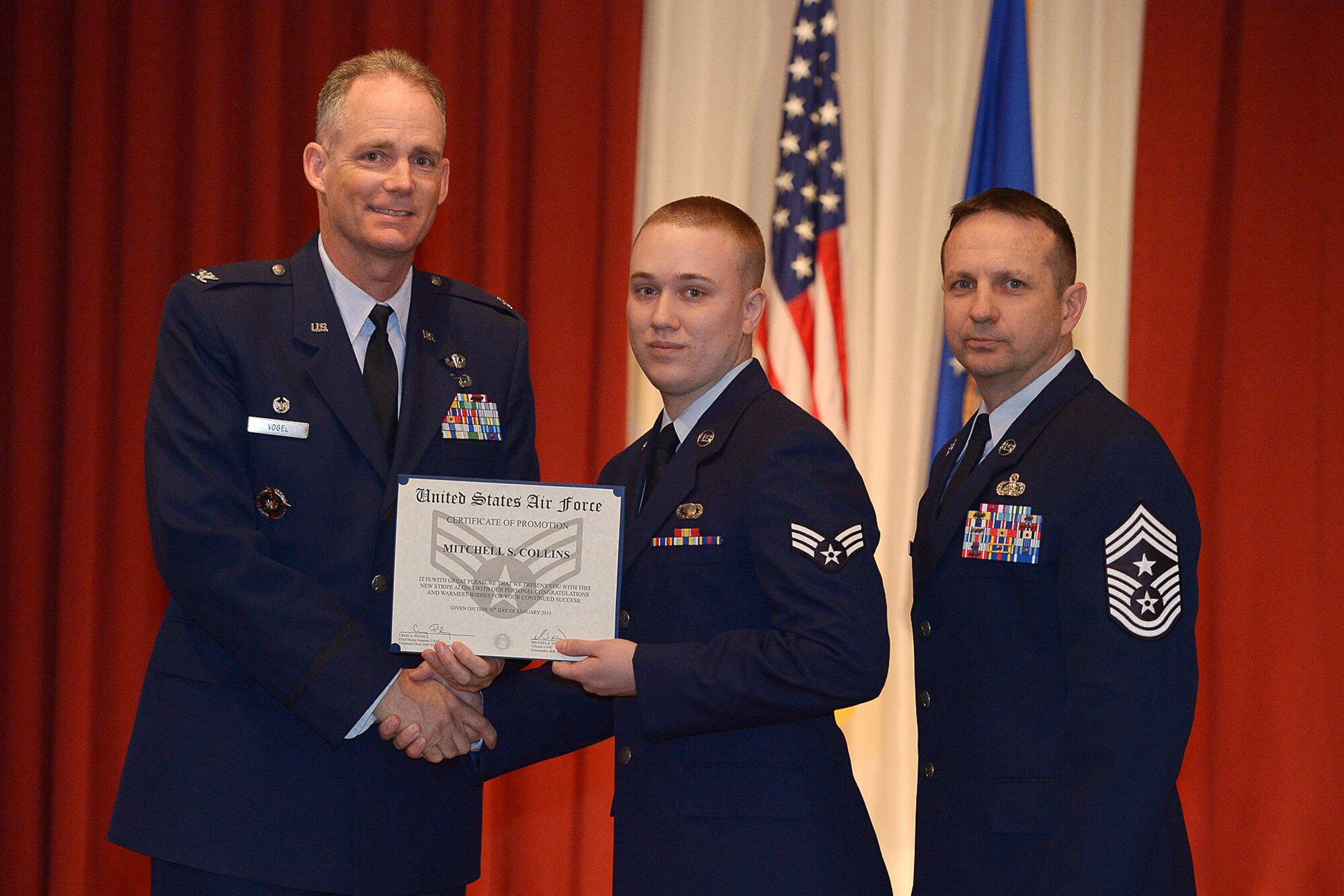 Col. Michael A. Vogel, 66th Air Base Group commander, and Hanscom Command Chief Master Sgt. Craig A. Poling pose alongside newly promoted Senior Airman Mitchell S. Collins, 66th Comptroller Squadron customer service technician, during the monthly enlisted promotion ceremony at the Minuteman Commons Jan. 30. The monthly enlisted promotion ceremony, which is generally held the last duty day of the month, provides the Hanscom community an opportunity to recognize enlisted members that are selected for promotion. (U.S. Air Force photo by Jerry Saslav)