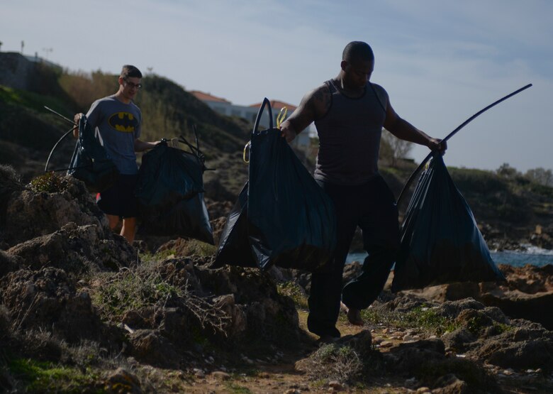 U.S. Air Force Staff Sgt. Jason Wells, a 52nd Expeditionary Logistics Readiness Squadron fuels dsitribution supervisor, right, and U.S. Air Force Senior Airman Robert McKittrick, a 52nd ELRS fuels journeyman, left, carry bags of trash during a beach cleanup at Chania, Greece, Jan. 31, 2015. The Airmen collected more than 150 pounds of trash during the project. (U.S. Air Force photo by Staff Sgt. Joe W. McFadden/Released) 