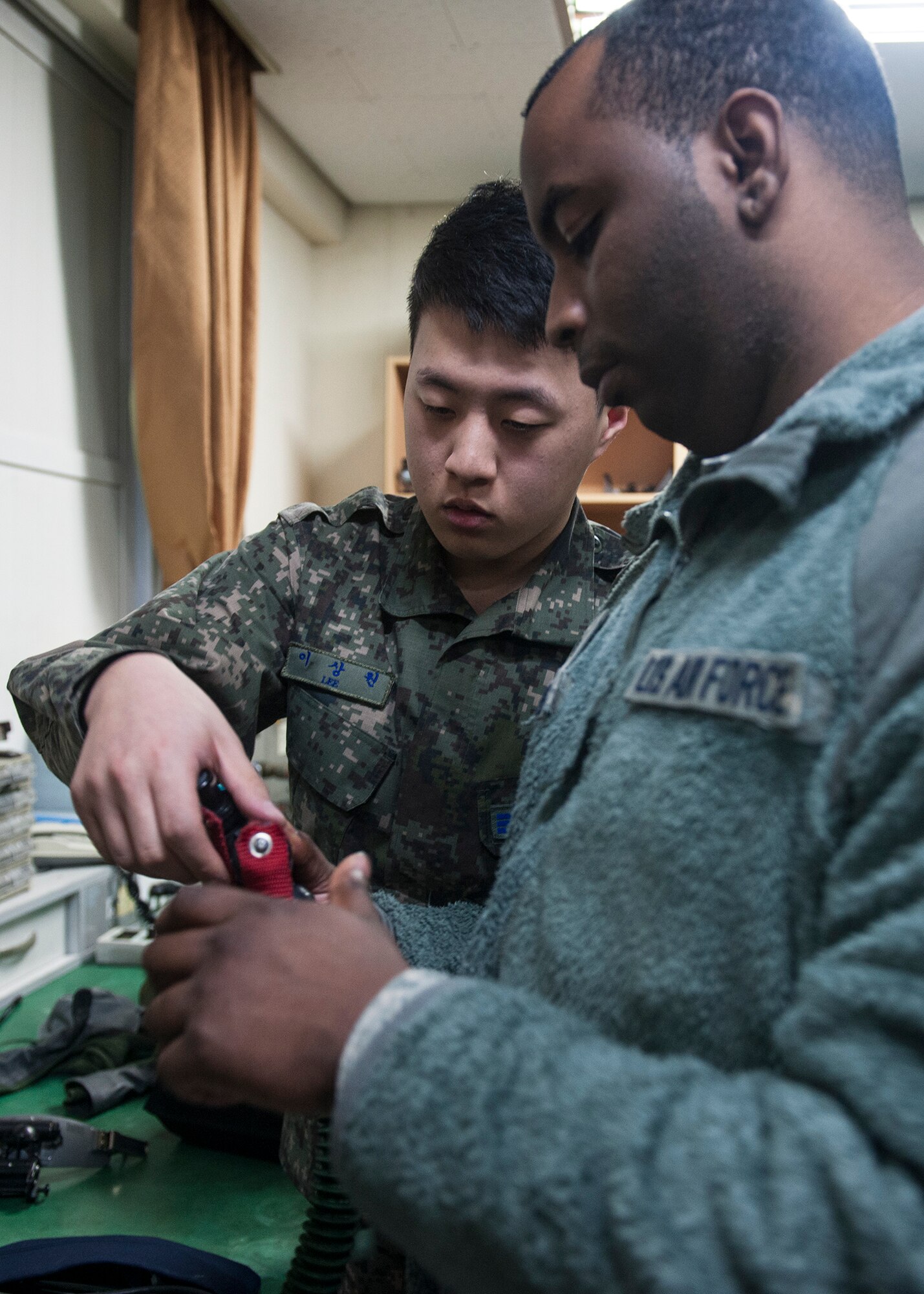 Senior Airman Sang Won Lee, 120th Fighter Squadron aircrew flight equipment technician (left), and Senior Airman John Temple, 8th Operations Support Squadron aircrew flight equipment journeyman, prepare to conduct a 12-p mask fit test during Exercise Buddy Wing 15-2, at Daegu Air Base, Republic of Korea, Feb. 4, 2015. Conducted multiple times a year to promote cultural awareness and sharpen combined combat capabilities, enlisted personnel from the Wolf Pack worked alongside their ROKAF counterparts during the four-day exercise. (U.S. Air Force photo by Senior Airman Katrina Heikkinen/Released)