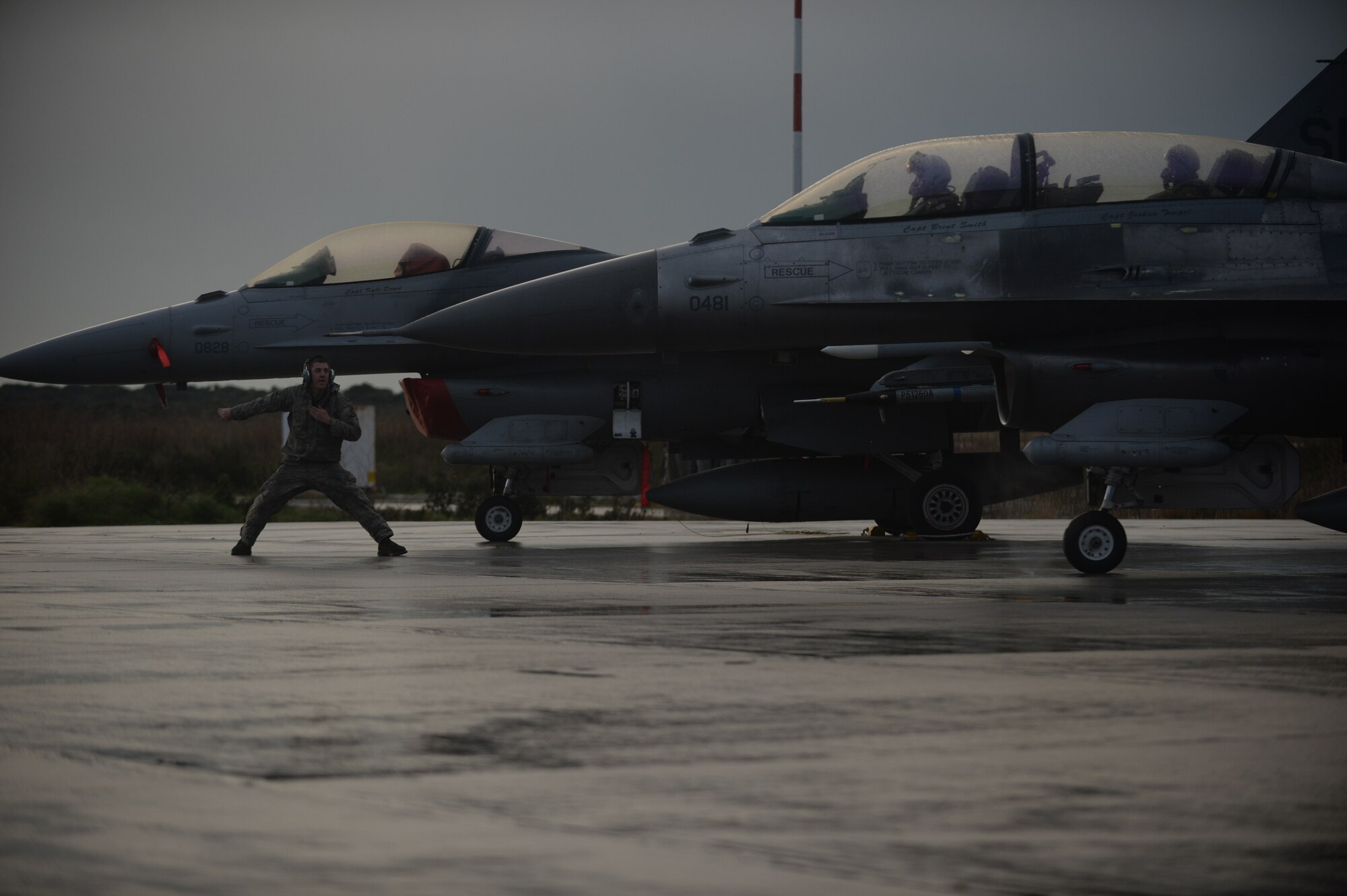 U.S. Air Force Airman 1st Class Zachary Jung, an assistant crew chief assigned to the 52nd Expeditionary Aircraft Maintenance Squadron, signals an F-16 Fighting Falcon fighter aircraft assigned to the 480th Expeditionary Fighter Squadron for departure from the flightline during a flying training deployment at Souda Bay, Greece, Jan. 29. 2015. Jung, along with 300 personnel from Spangdahlem Air Base, Germany, participated in the flying training deployment between the Hellenic and U.S. Air Forces at Souda Bay, Jan. 16-Feb. 13, 2015. (U.S. Air Force photo by Staff Sgt. Joe W. McFadden/Released)