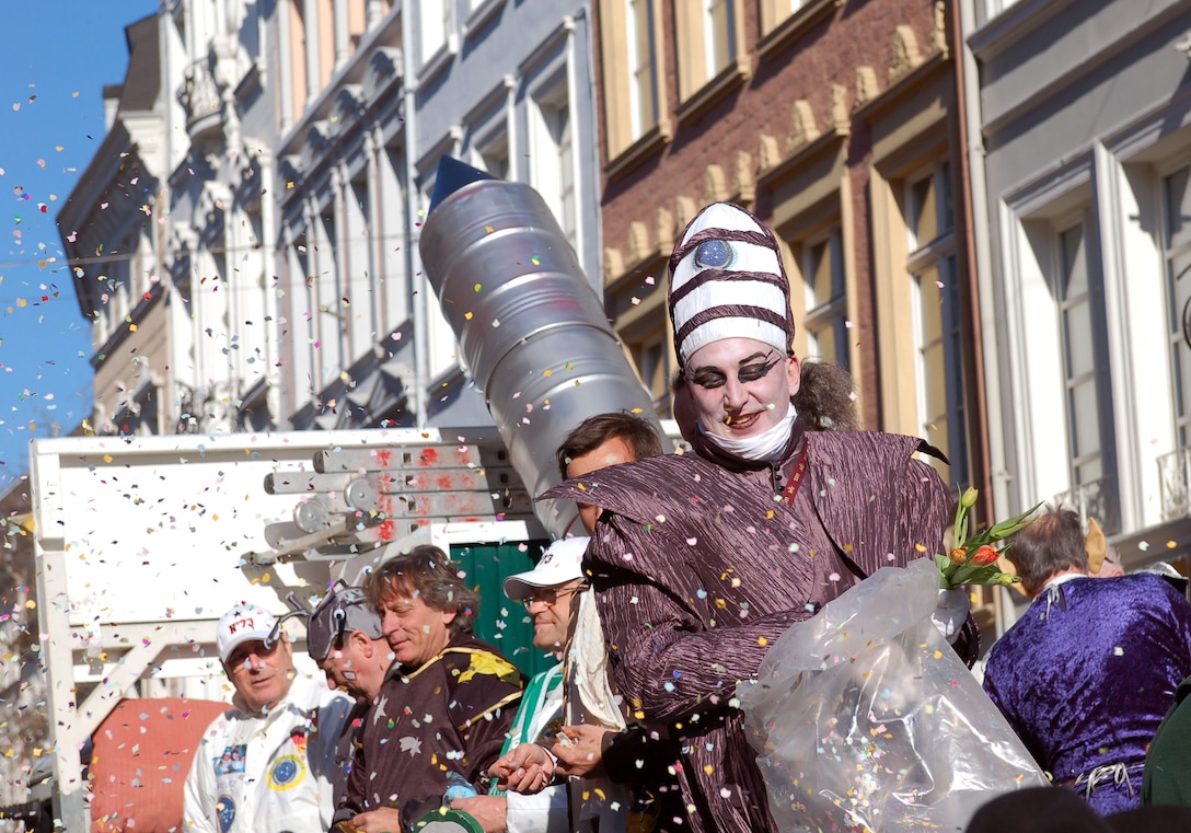 The Harlequin spreads confetti over the crowd during a past Fasching parade in Trier, Germany. Many local communities will host Fasching parades up until Ash Wednesday, Feb. 18.  Many of the parades will take place Feb. 14-16. Observers stand in the streets, cheering, singing and dancing. For any parade, people and children are advised to bring bags to collect the candies and sweets that the Fasching fools hand out or throw into the crowd. Although it is not a must, some people dress up for viewing a parade. Music and entertainment typically occurs in public spots following the parades. (U.S. Air Force photo by Iris Reiff/Released) 