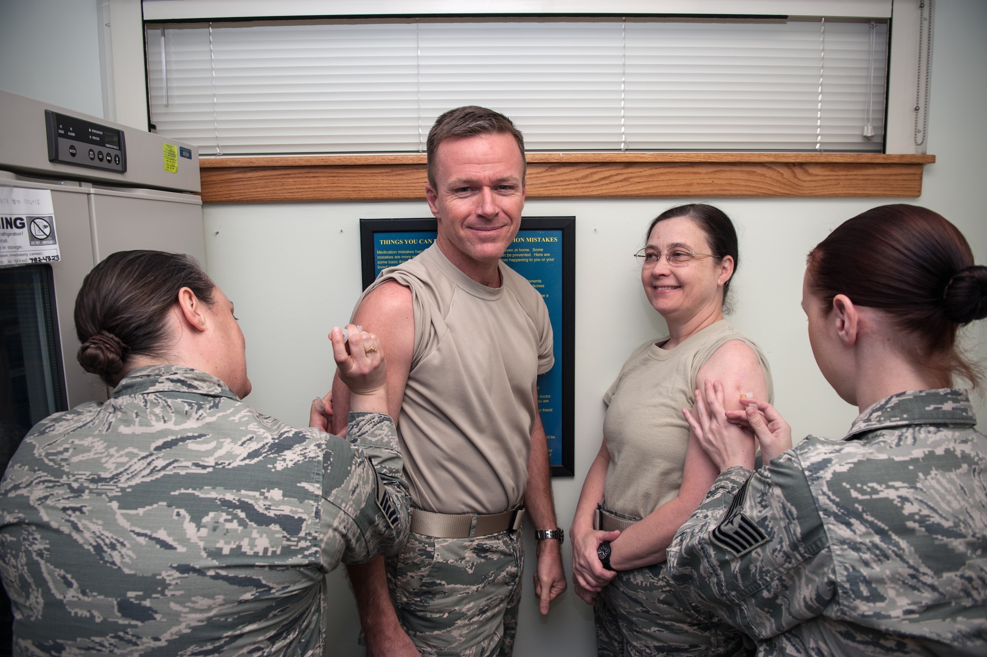 Col. Ken “Wolf” Ekman, 8th Fighter Wing commander, and Col. Tambra “Hawk” Yates, 8th Medical Group commander, receive their Japanese Encephalitis vaccine in the immunizations laboratory at Kunsan Air Base, Republic of Korea, Feb. 3, 2015. As of Feb. 1, the JEV will be a required immunization for all Airmen assigned to Japan and Korea. (U.S. Air Force photo by Senior Airman Taylor Curry/Released) 