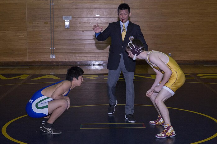 Wrestlers from Matthew C. Perry High School and the Tabuse Agricultural and Technical School face-off during a tournament, Jan. 31, 2015, inside IronWorks Gym aboard Marine Corps Air Station Iwakuni, Japan. In this tournament an individual from each weight class receives an award, not a team as a whole.