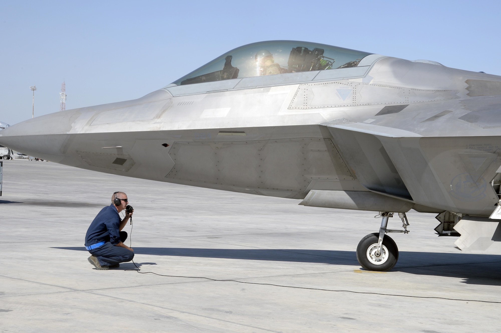 Senior Airman Benjamin, crew chief, kneels by an F-22 Raptor prior to take-off at an undisclosed location in Southwest Asia Jan. 26, 2015. Airmen with the Raptor AMU work around the clock ensuring the F-22 Raptor provides lethal and decisive airpower wherever and whenever needed. Benjamin is currently deployed from Tyndall Air Force Base, Fla., is a native of Hazel Green, Alabama. (U.S. Air Force/Tech. Sgt. Marie Brown)