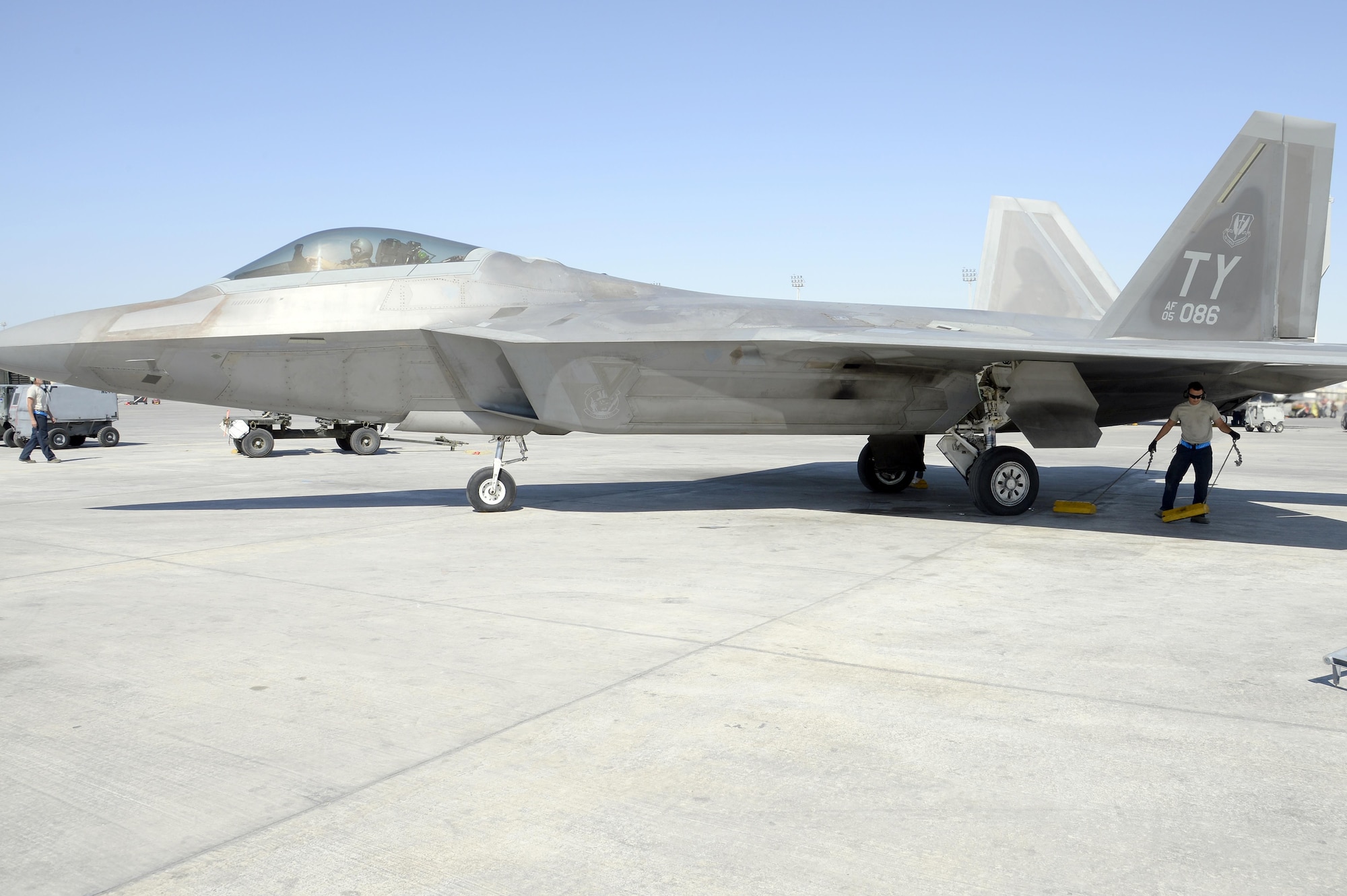 Senior Airman Dakota, launch assist, pulls chalks from an F-22 Raptor at an undisclosed location in Southwest Asia Jan. 26, 2015. Four different specialties work together to get the F-22 Raptor in the air. Dakota is currently deployed from Tyndall Air Force Base, Fla., and is a native of El Paso, Texas. (U.S. Air Force/Tech. Sgt. Marie Brown)

