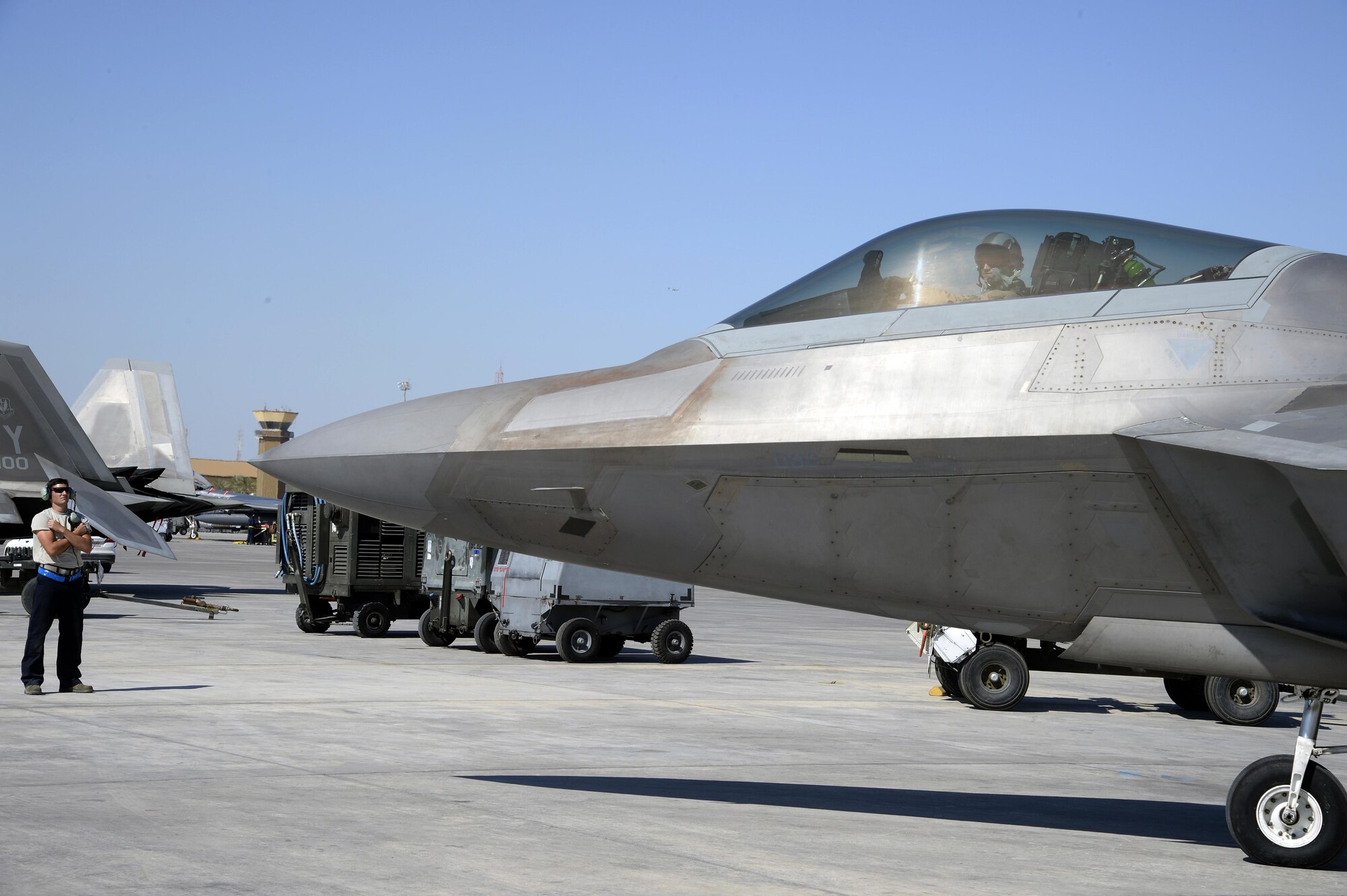 Airman 1st Class Kyle, crew chief, prepares to marshall out an F-22 Raptor at an undisclosed location in Southwest Asia Jan. 26, 2015. This is the first combat deployment for the Raptor Aircraft Maintenance Unit, which is currently deployed from the 95th AMU from Tyndall Air Force Base, Fla. Kyle is currently deployed from Tyndall Air Force Base, Fla., and is a native of  Eagle River, Alaska. (U.S. Air Force/Tech. Sgt. Marie Brown)