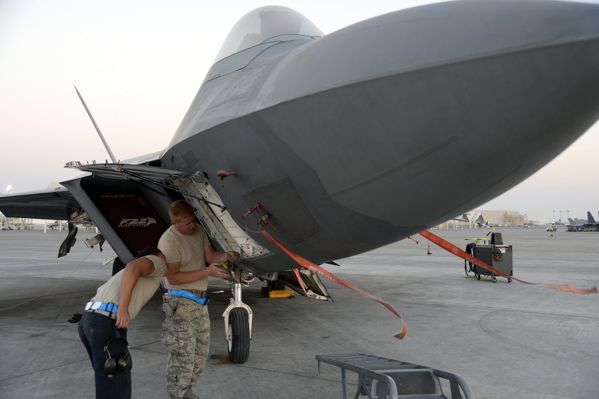 Staff Sgt. James, avionics craftsman, right, and Senior Airman Dakota, launch assist, troubleshoots a communications, navigation and identification system on an F-22 Raptor at an undisclosed location in Southwest Asia Jan. 26, 2015. The F-22 Raptor is the first aircraft to use integrated avionics, where the radar, weapons management system and electronic warfare system work as one, giving the pilot unprecedented situational awareness. James is currently deployed from Tyndall Air Force Base, Fla., and is a native of Frackville, Pa. Dakota is currently deployed from Tyndall AFB, Fla., and is a native of El Paso, Texas. (U.S. Air Force/Tech. Sgt. Marie Brown)
