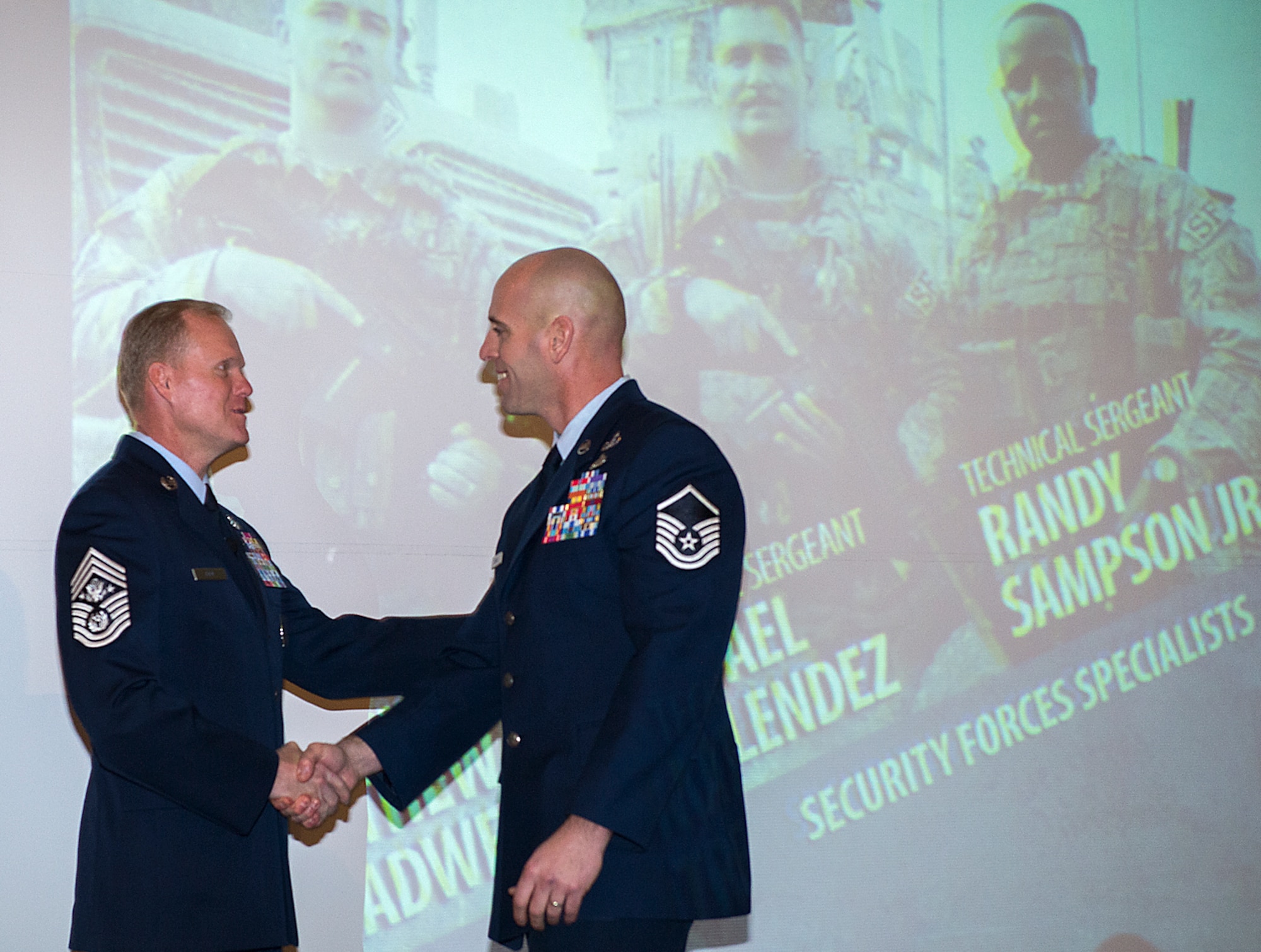Chief Master Sgt. of the Air Force James Cody congratulates Master Sgt. Michael Sears after Cody gave the keynote address during a luncheon honoring Sears and the other Airmen from the Air Force's ninth volume of Portraits in Courage, Feb. 4, 2015, in, Arlington, Va. During the luncheon the Airmen told their stories to a group of Air Force civic leaders from around the country. Portraits in Courage is an Air Force program highlighting Airmen for their honor, valor, devotion and selfless sacrifice in the face of extreme danger to themselves and others. (U.S. Air Force photo/Jim Varhegyi)
