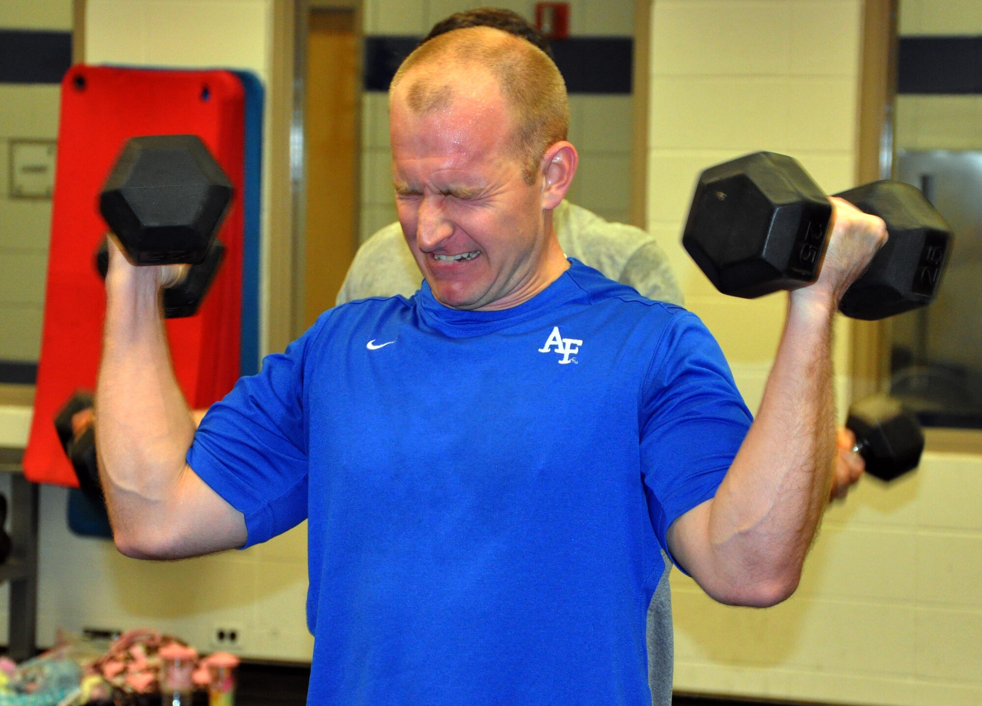 Master Sgt. Jay Guldjord, a refueling boom operator assigned to the Air Force Reserve 18th Air Refueling Squadron, 931st Air Refueling Group, McConnell Air Force Base, Kan., strains to complete a set of high repetition dumbbell curls during a group workout at the base fitness center, Feb. 4, 2015. Several members of the 18 ARS meet at the fitness center daily to participate in organized group workouts to improve overall unit fitness and to stay "fit to fight." (U.S. Air Force photo by Capt. Zach Anderson)