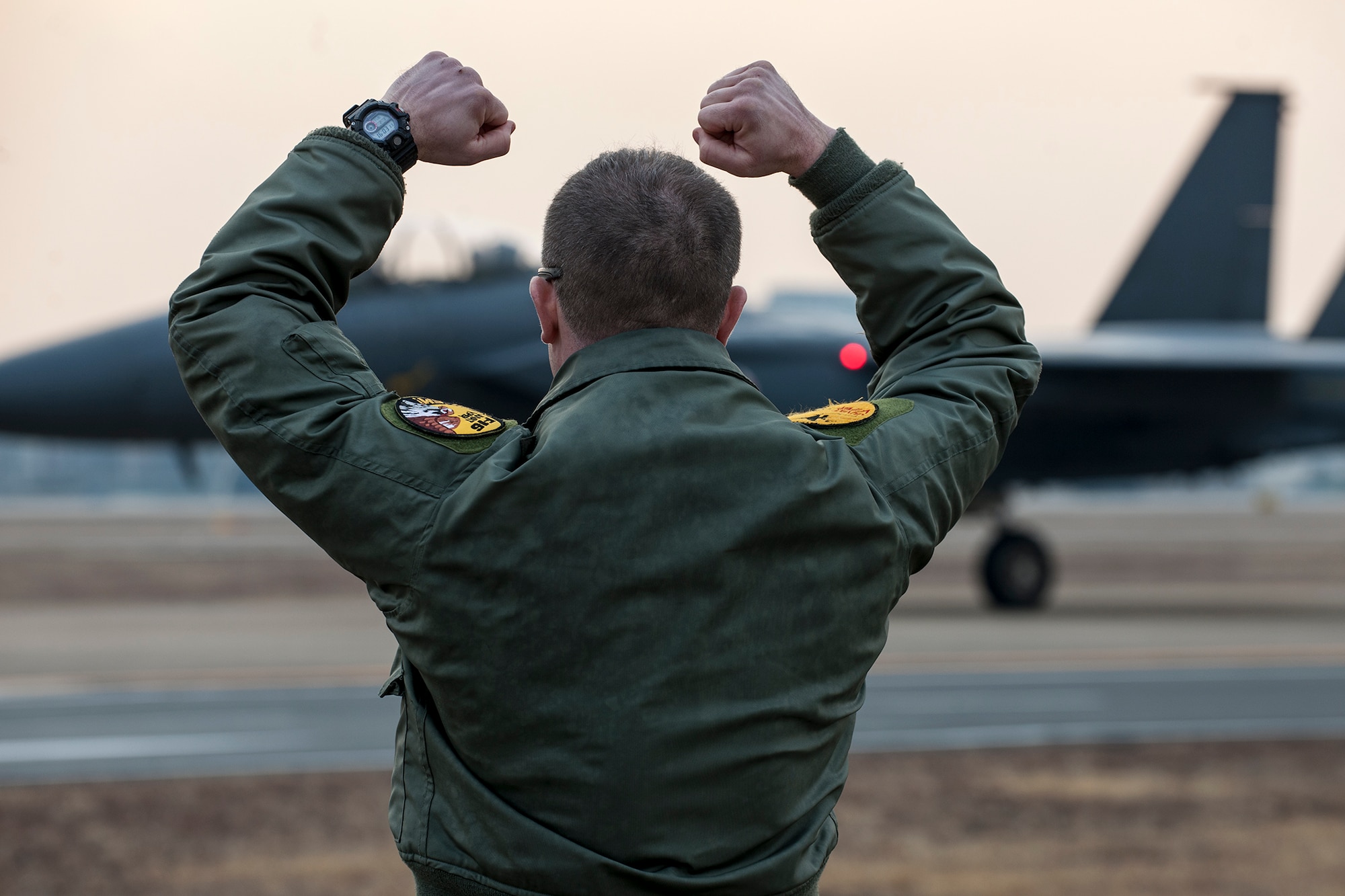 Maj. Dean Laansma gives the 80th Fighter Squadron "Crush 'em" gesture to an F-15K Slam Eagle as it taxis during exercise Buddy Wing 15-2 Feb. 5, 2015, at Daegu Air Base, South Korea. The 8th Fighter Wing deployed four F-16 Fighting Falcons to fly alongside the South Korean air force’s 11th FW's F-15Ks during the four-day exercise. Laansma is the 80th Fighter Squadron assistant director of operations and exercise Buddy Wing detachment commander. (U.S. Air Force photo/Senior Airman Katrina Heikkinen) 