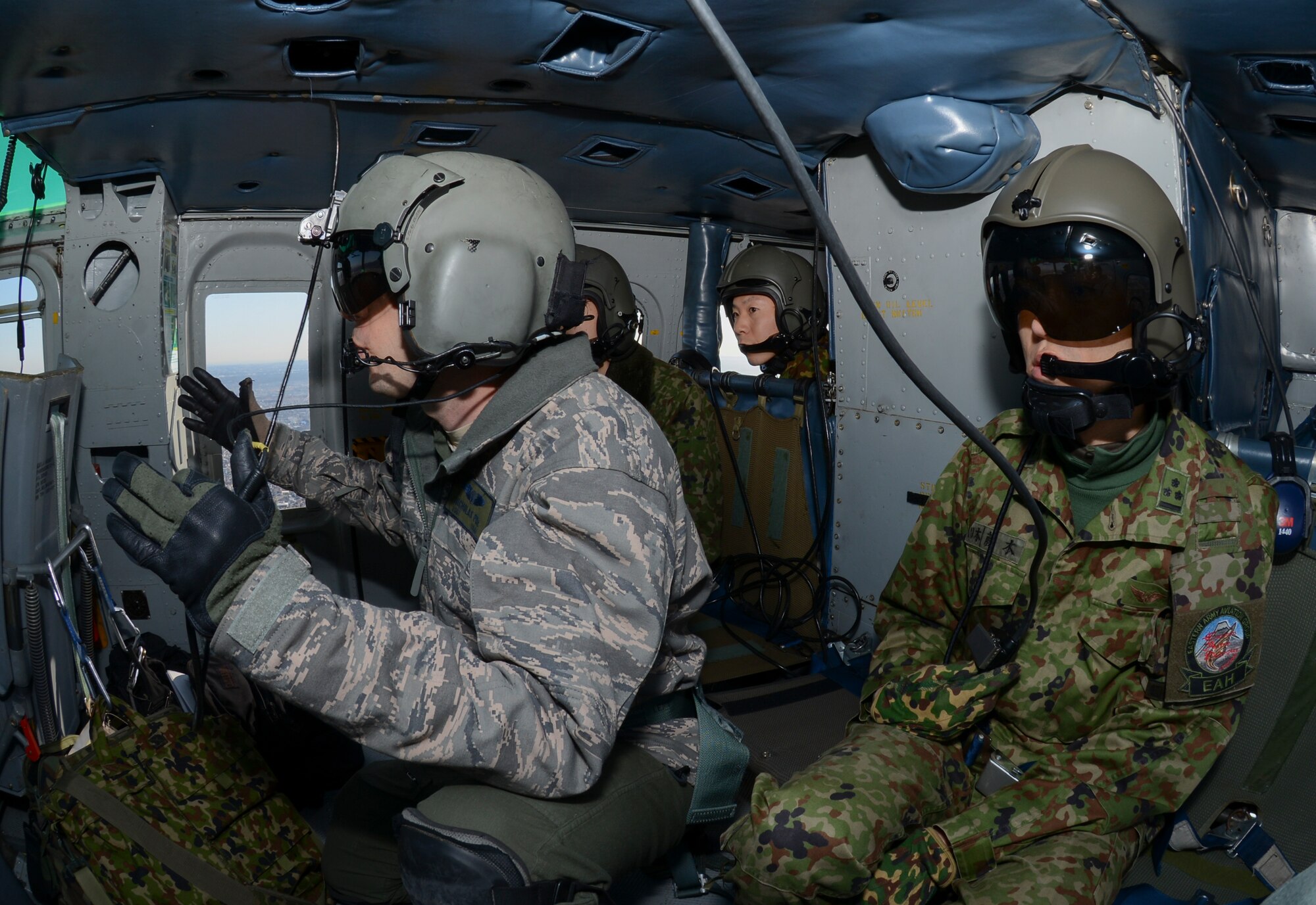Members of the Japan Ground Self-Defense Force (JGSDF) ride along with U.S. service members as they perform formation maneuvers during a bilateral training mission Jan. 29, 2015, near Tokyo. U.S. and JGSDF members conducted the exchange mission to deepen their understanding of each other’s tactics, techniques and procedures. (U.S. Air Force photo/Senior Airman Michael Washburn)