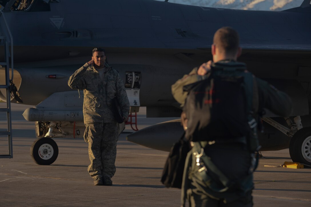 U.S. Air Force Staff Sgt. Christopher Pridgen salutes an F-16 Fighting Falcon pilot Jan. 30, 2015, during a flying training deployment at Souda Bay, Greece. Crew chiefs perform pre-flight and secondary inspections of the aircraft before pilots taxi the aircraft to the flightline for takeoff. Pridgen is a crew chief assigned to the 52nd Expeditionary Aircraft Maintenance Squadron and the pilot is assigned to the 480th Expeditionary Fighter Squadron. (U.S. Air Force photo/Staff Sgt. Joe W. McFadden)