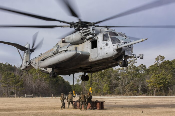 Landing support specialists with Combat Logistics Battalion 2, Combat Logistics Regiment 2, 2nd Marine Logistics Group, prepare to attach an 8,500 pound beam to a CH-53 Super Stallion helicopter with Marine Heavy Helicopter Training Squadron 302, Marine Aircraft Group 29, 2nd Marine Aircraft Wing, during helicopter support team operations aboard Camp Lejeune, N.C., Jan. 29, 2015. A CH-53 Super Stallion helicopter is able to lift approximately 10,000 pounds. (U.S. Marine Corps photo by Cpl. James R. Smith/Released)