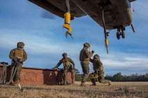 Landing support specialists with Combat Logistics Battalion 2, Combat Logistics Regiment 2, 2nd Marine Logistics Group, prepare to ground out a CH-53 Super Stallion helicopter with Marine Heavy Helicopter Training Squadron 302, Marine Aircraft Group 29, 2nd Marine Aircraft Wing, before attaching an 8,500 pound beam during helicopter support team operations aboard Camp Lejeune, N.C., Jan. 29, 2015. The Marines ground out the helicopter first because it generates a lot of electricity that can harm the Marines attaching the load. (U.S. Marine Corps photo by Cpl. James R. Smith/Released)