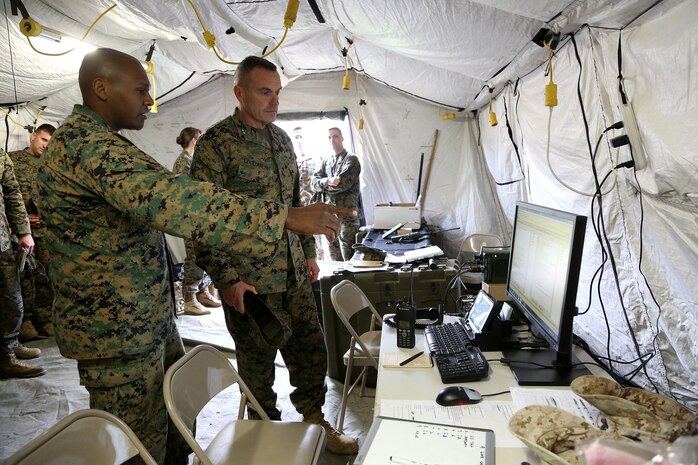 Major Elishama Wheeler, G-6 Operations Officer, Headquarters Regiment, 1st Marine Logistics Group, explains an emerging communications capability called digital interoperability to Maj. Gen. Vincent A. Coglianese, 1st MLG Commanding General, during an en-route care exercise aboard Camp Pendleton, Calif., Jan. 28, 2015. During the four-day exercise, corpsmen trained to prepare a Special-Purpose Marine Air-Ground Task Force group that is going to forward deploy later this year. The more than 40 corpsmen set up a shock trauma platoon facility, or mobile emergency room, to treat simulated casualties. The casualties were stabilized in the STP and then flown out via aircraft. (U.S. Marine Corps photo by Sgt. Laura Gauna/Released)
